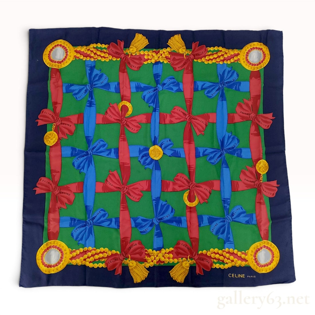 Celine Paris Square Silk Scarf: Vintage Celine Paris square silk scarf featuring a vibrant design of interwoven red and blue branded ribbons on a green field with gold-toned jewelry motifs. Composed of 100% silk with hand-rolled edg