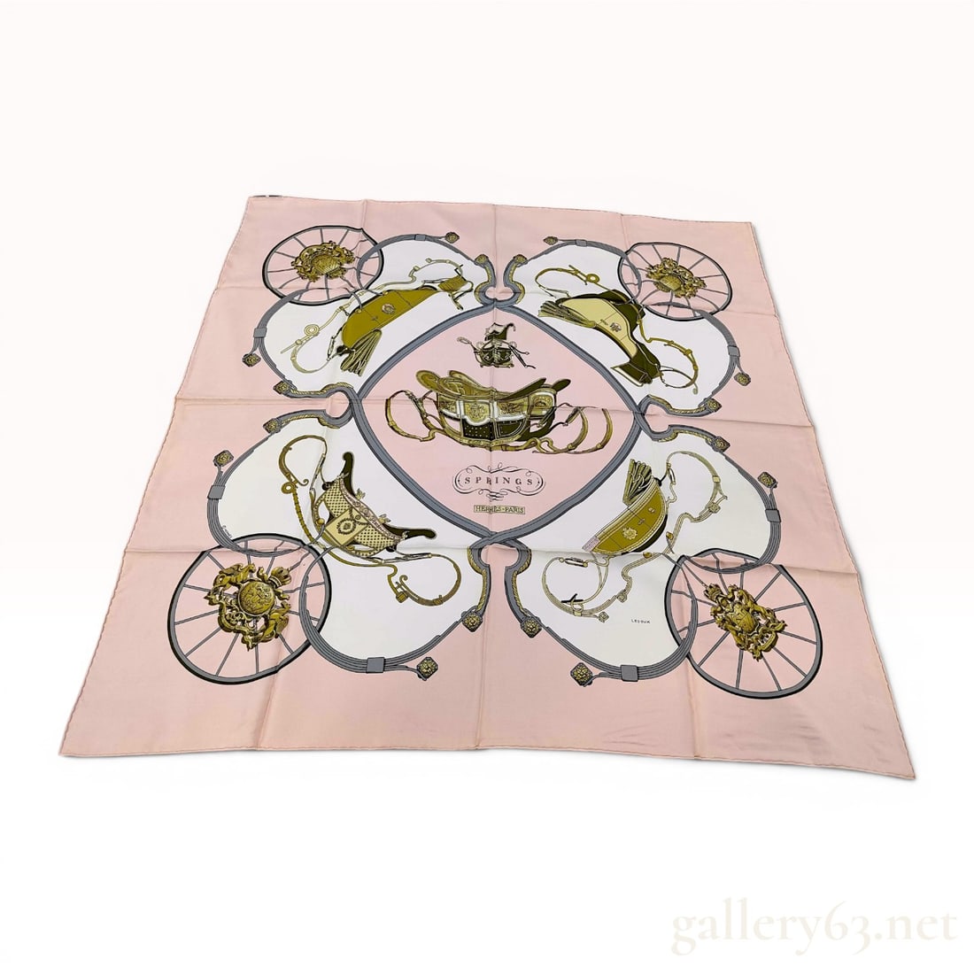 Hermes Springs Silk Carre Scarf by Philippe Ledoux: Hermes silk carre scarf in the Springs pattern, designed by Philippe Ledoux. The design features detailed historic carriages and heraldic crests in gold and olive tones on a pale pink and white ground