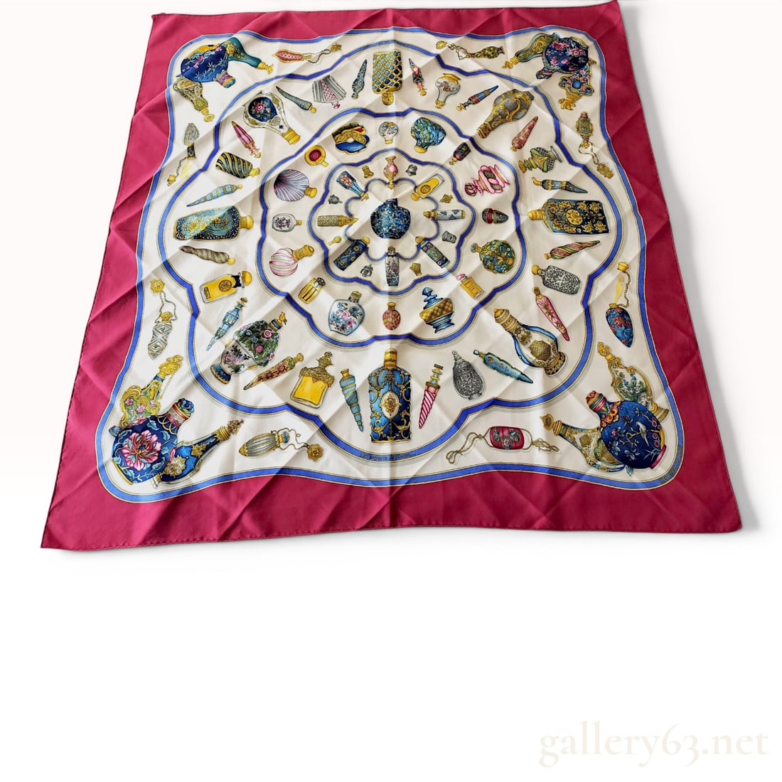 Hermes Qu'importe le flacon... Silk Scarf: A square silk twill scarf from Hermes featuring the Qu'importe le flacon... pattern, originally designed by Catherine Baschet and first issued in 1988. The design showcases an array of antique and vin