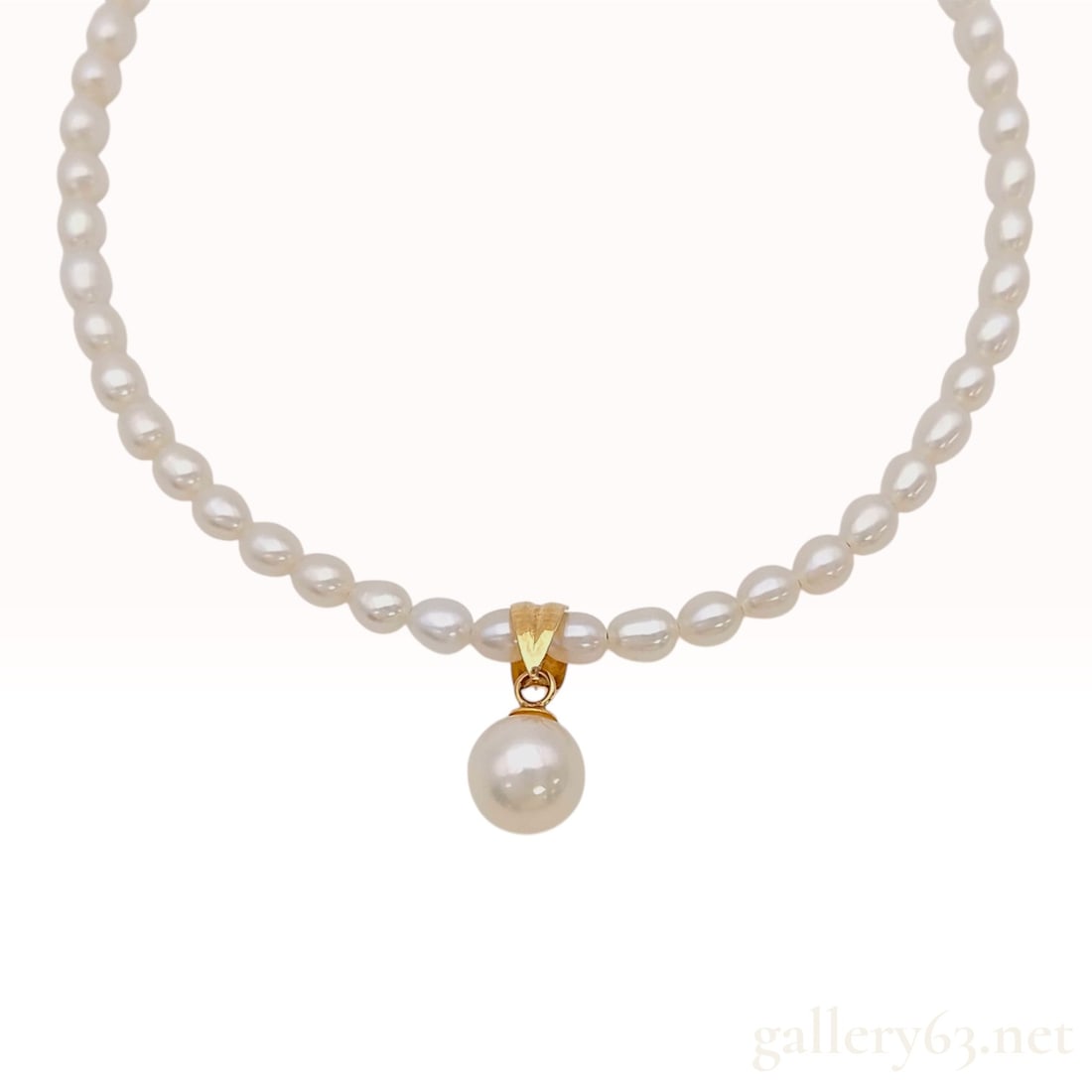 18K Yellow Gold and Cultured Pearl Pendant Necklace: A necklace featuring a single strand of small white cultured pearls with a central pendant. The pendant consists of a single round white cultured pearl measuring approximately 7.5mm in diameter, suspe