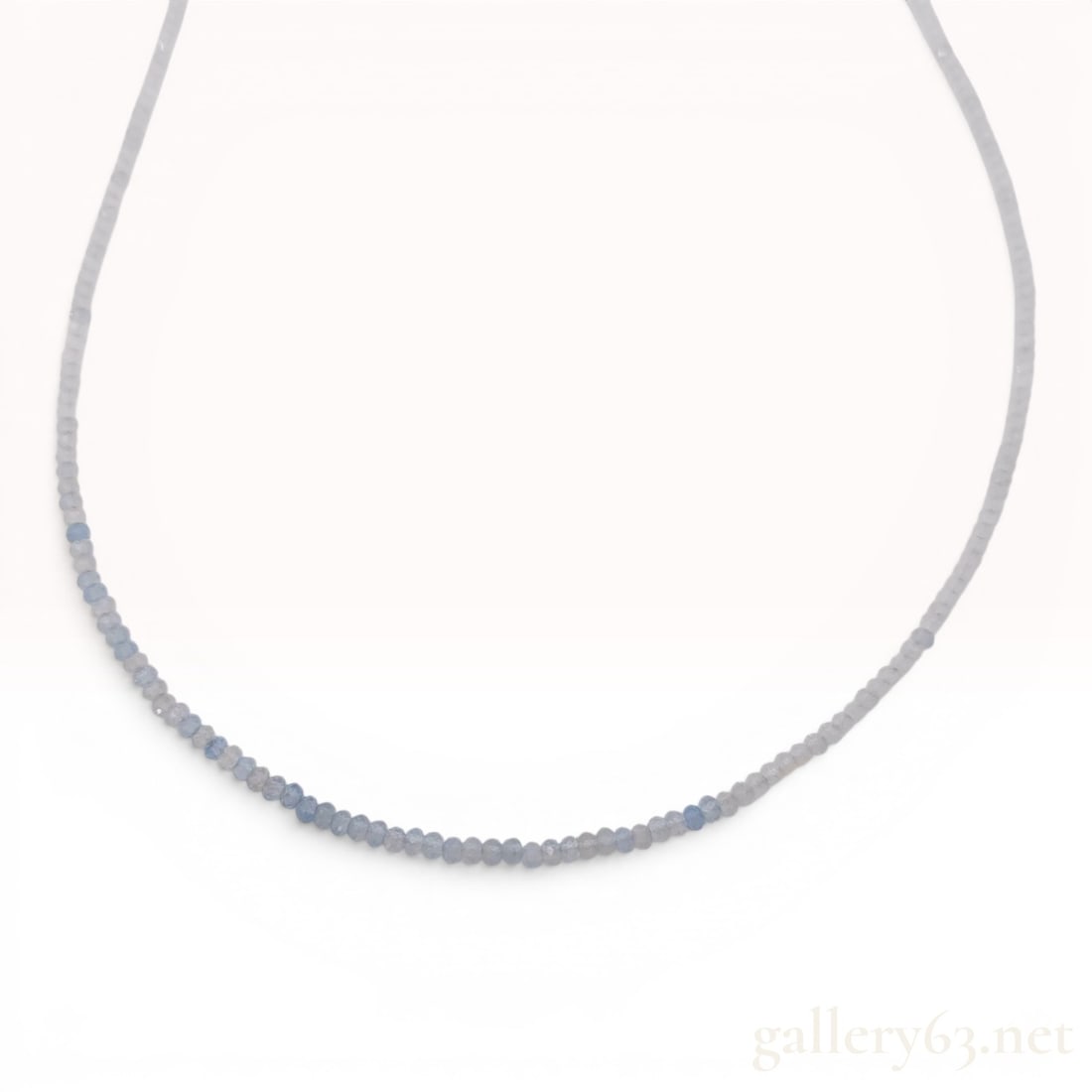 Natural Aquamarine Faceted Bead Necklace with Gold-Plated Sterling Silver Clasp: This necklace consists of a single strand of small, faceted natural aquamarine (beryl) beads. The gemstones display a range of light colors from pale translucent blue to grayish-blue. The necklace is 