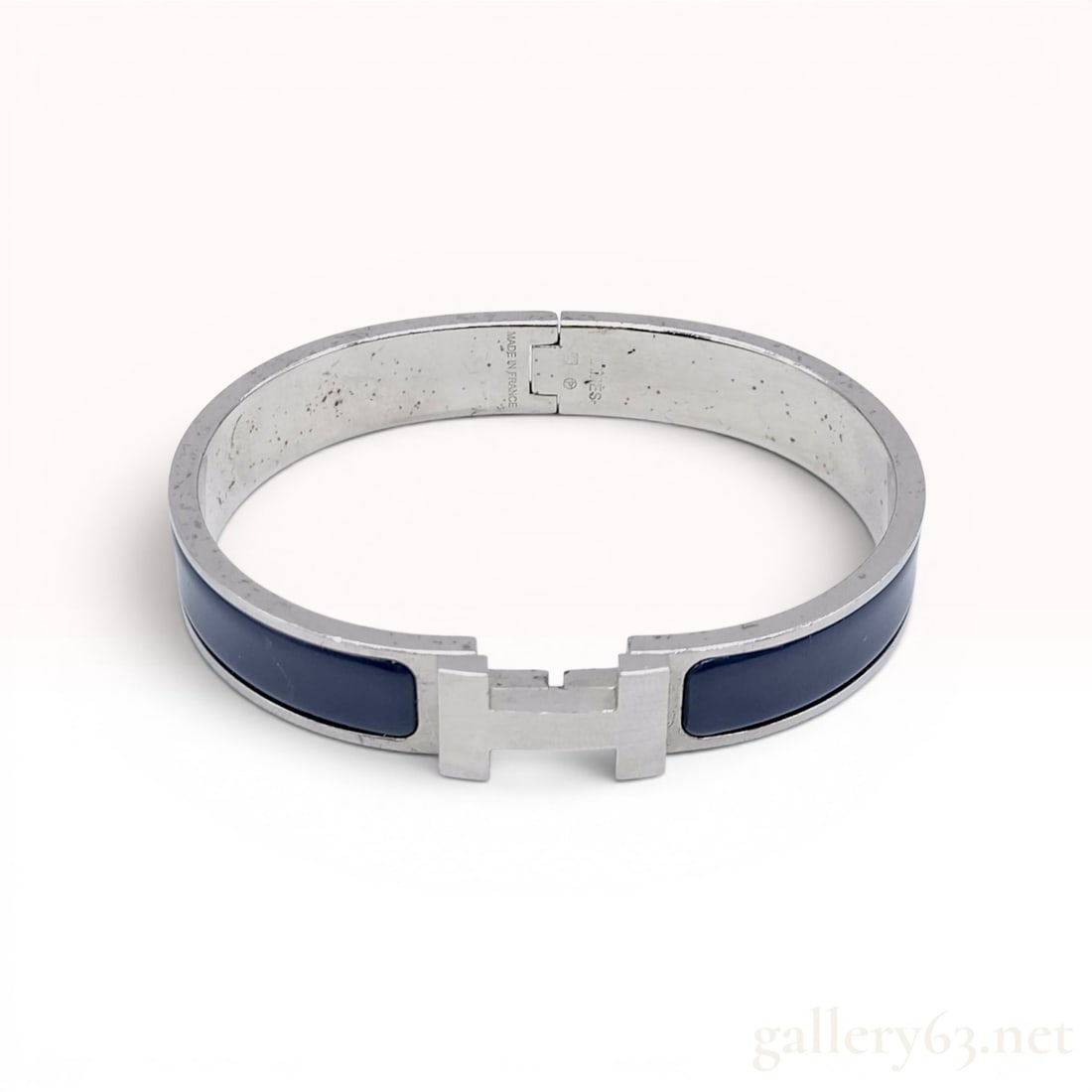 Hermes Clic H Enamel and Palladium-Plated Bangle Bracelet with Box: This Hermes Clic H bangle bracelet features dark blue enamel insets set within a silver-tone metal frame. The bracelet incorporates the signature H-shaped swivel clasp mechanism. The interior of the m