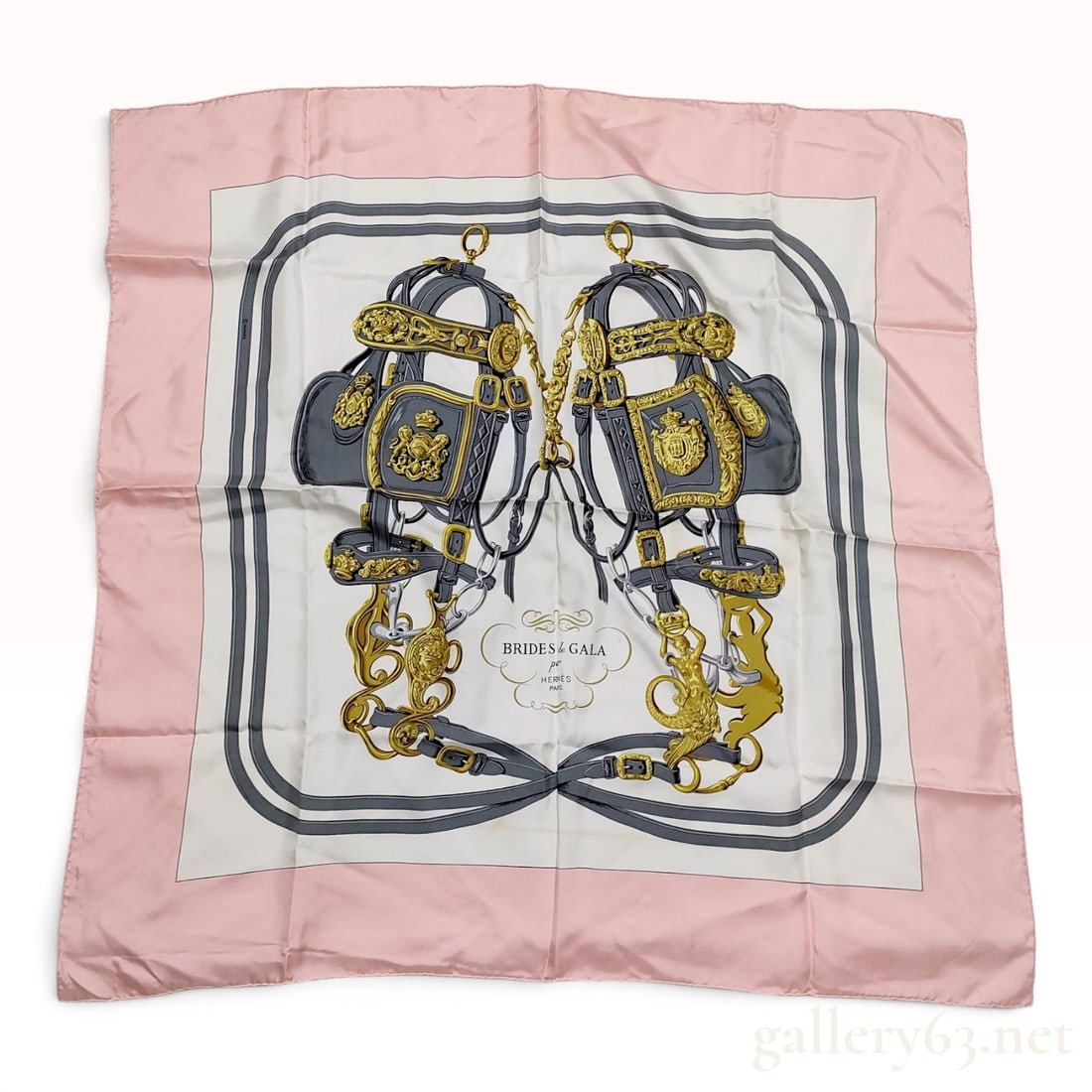 Hermes Brides de Gala Silk Carre 90 Scarf: This Hermes silk scarf features the Brides de Gala pattern, originally designed by Hugo Grygkar in 1957. The central motif depicts two highly ornate ceremonial horse bridles with intricate gold-toned 