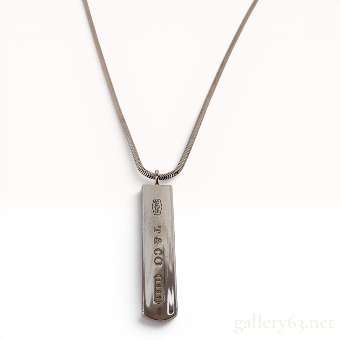 Tiffany and Co 1837 Sterling Silver Bar Pendant Necklace: A sterling silver pendant necklace from the Tiffany 1837 collection by Tiffany and Co. The jewelry features a rectangular bar pendant with a slightly curved profile, suspended from a sterling silver s