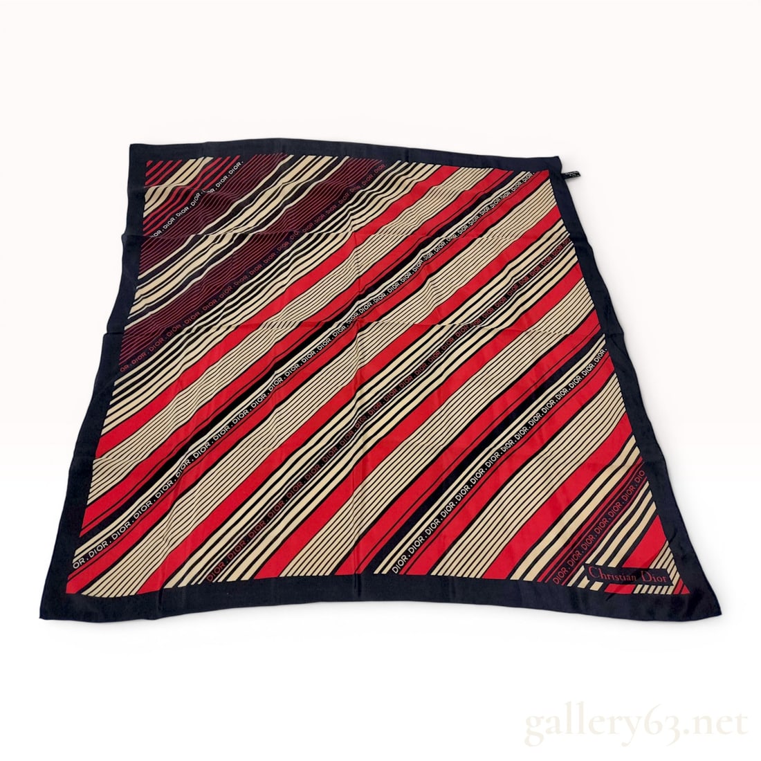Christian Dior Vintage Silk Diagonal Stripe Square Scarf: A vintage square scarf from Christian Dior featuring a bold diagonal stripe pattern in navy blue, red, and cream. The design integrates a repeating Dior logotype motif throughout several of the stripe