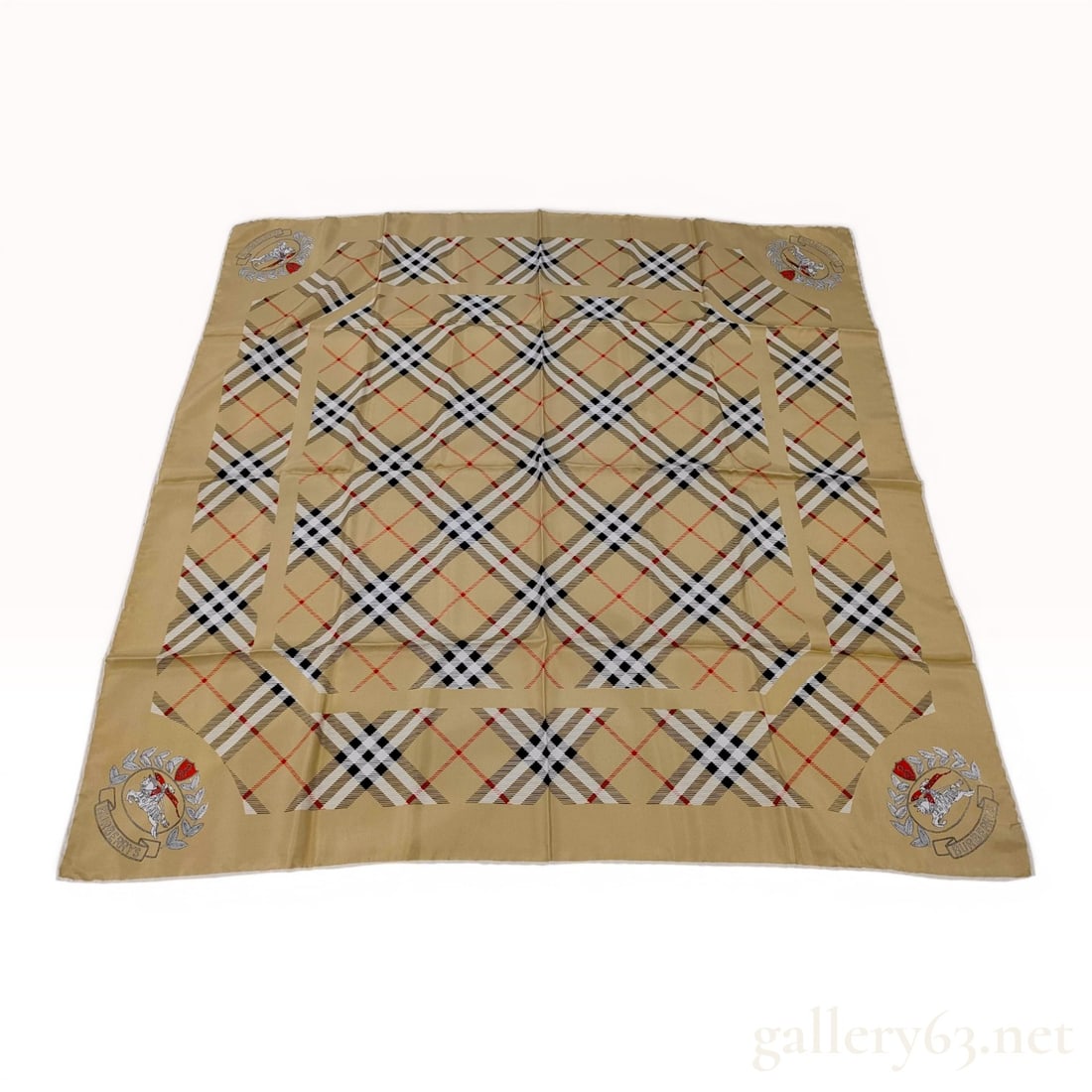 Vintage Burberrys Square Silk Scarf with Equestrian Knight Logo: A square silk scarf by Burberrys featuring a diagonal check pattern in tan, black, white, and red. The central grid of checks is framed by a solid tan border. Each corner is decorated with the Equestr