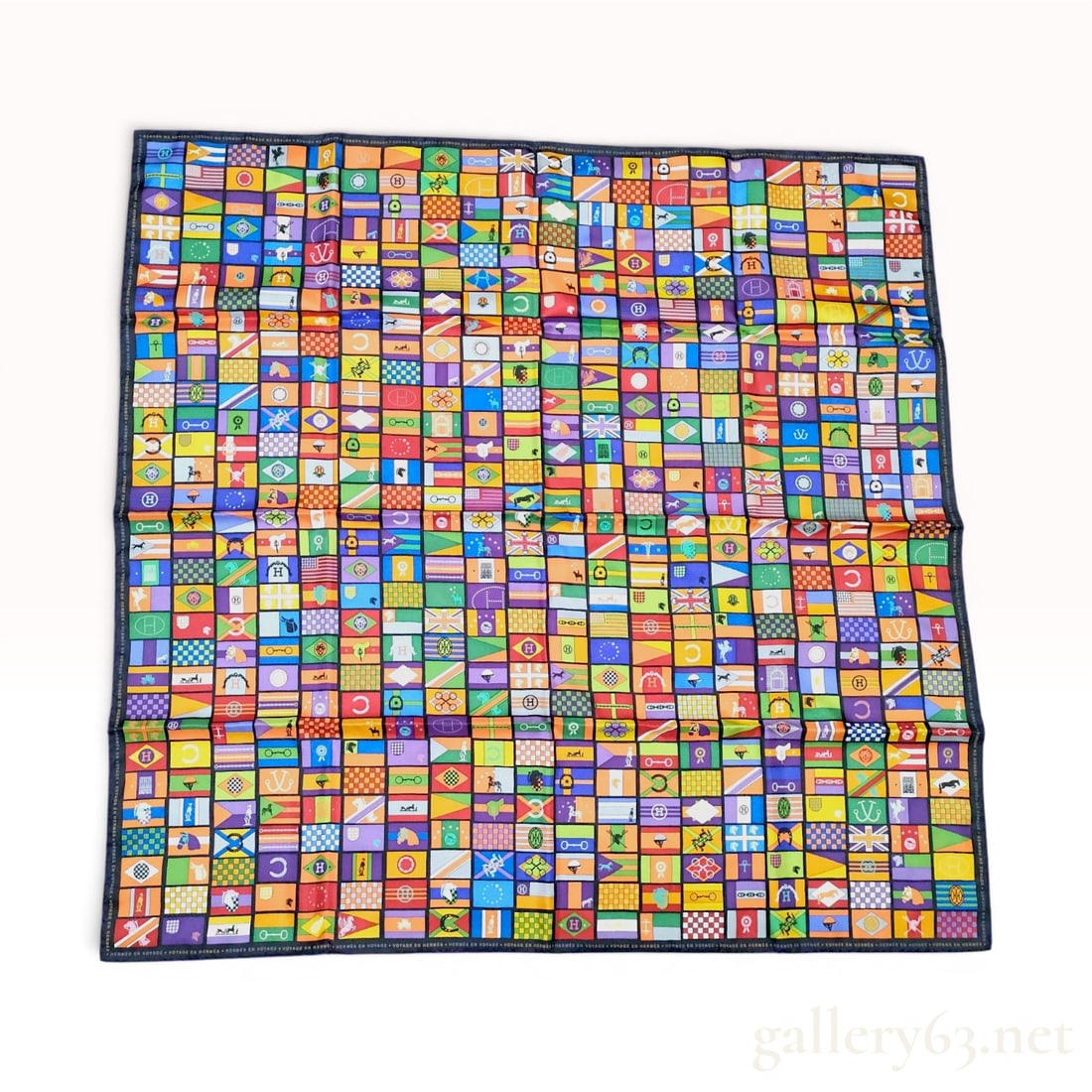Hermes Voyage en Hermes Silk Scarf: An authentic Hermes Paris silk square scarf featuring the Voyage en Hermes pattern. The design consists of a dense, vibrant multi-colored grid of rectangular panels, each illustrating equestrian-theme