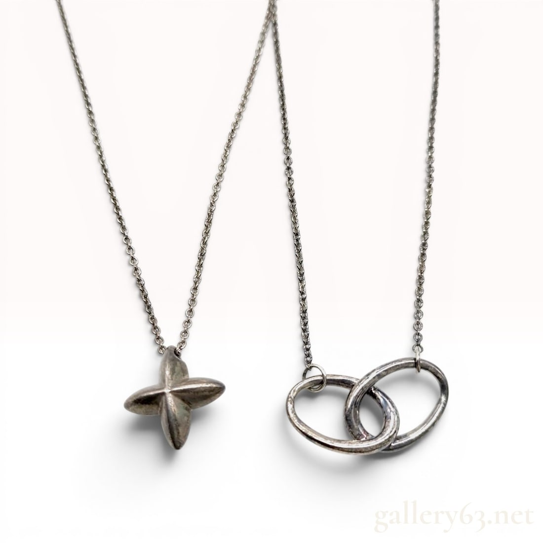 Two Tiffany and Co. Elsa Peretti Sterling Silver Star and Interlocking Circles Necklaces: Two sterling silver necklaces designed by Elsa Peretti for Tiffany and Co. The first necklace features a three-dimensional, four-pointed puffed star pendant suspended from a fine cable-link chain. The