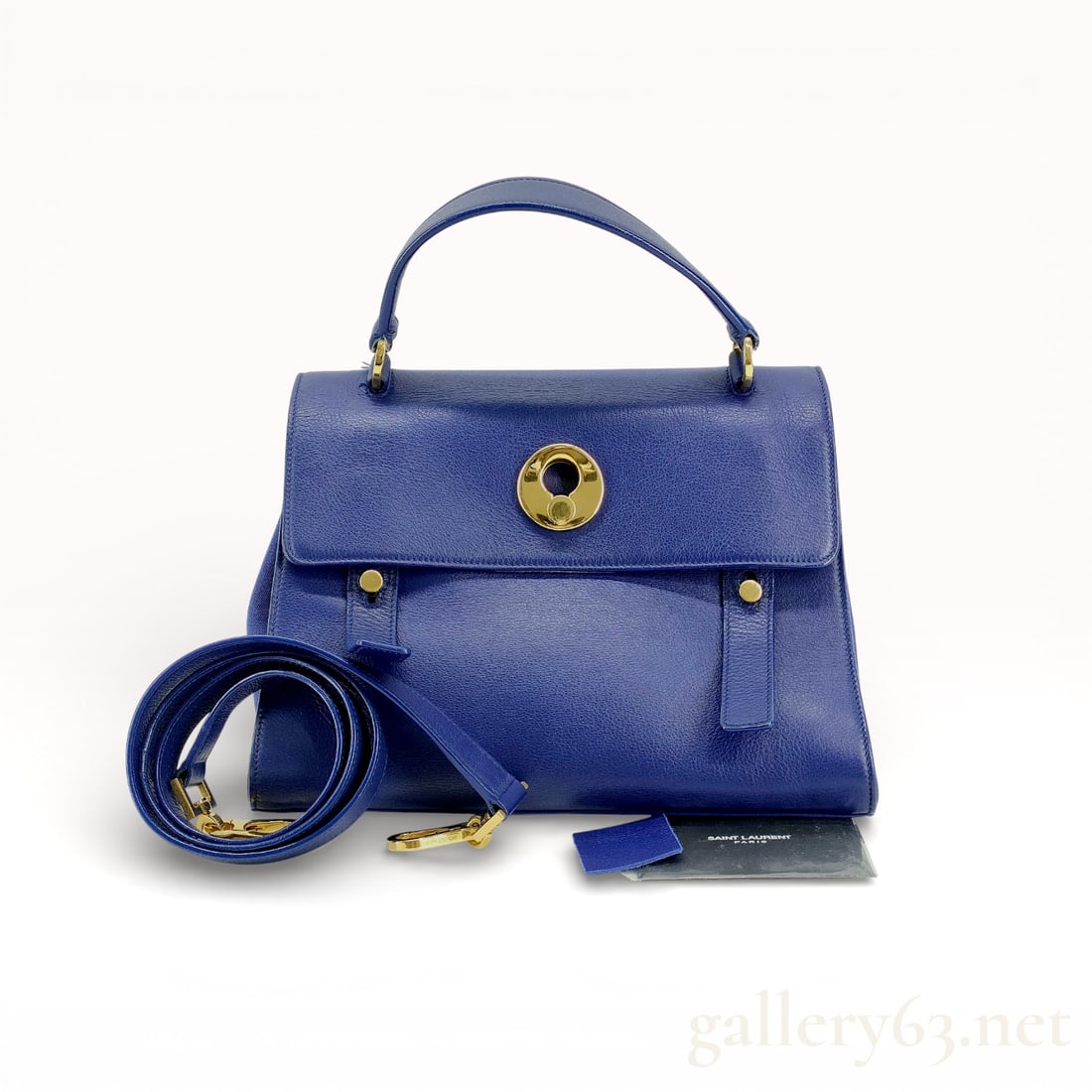 Saint Laurent Paris Muse Two Top Handle Bag in Cobalt Blue Leather: Saint Laurent Paris Muse Two top handle bag in cobalt blue grained leather with tonal canvas lining. The exterior features a front flap with a gold-tone keyhole lock, decorative vertical straps, a rea