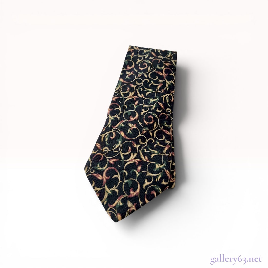 Christian Dior Monsieur Silk Foliate Scroll Necktie: Christian Dior Monsieur silk necktie. The piece features an all-over foliate scroll pattern in sage green, ochre, and burgundy on a navy blue ground with reddish-brown branded tipping. A black woven b