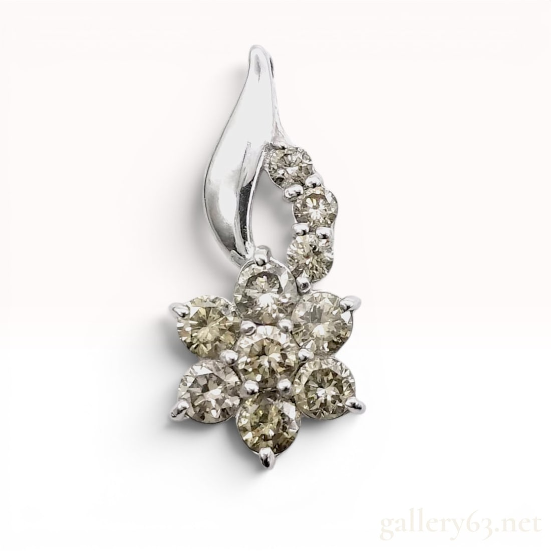 1.50ct Natural Champagne Diamond and 18K White Gold Flower Cluster Pendant: 18 karat white gold pendant featuring a floral cluster design set with round brilliant cut diamonds. The central seven-stone flower motif is surmounted by a curved, graduated bail set with five additi