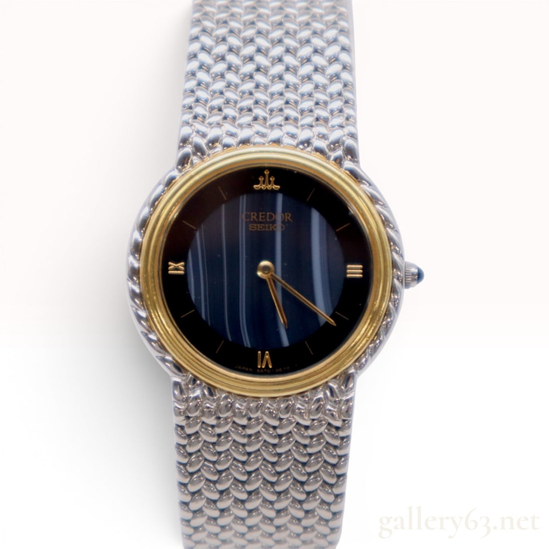 Credor Seiko 5A70-0260 Stainless Steel and 18kt Gold Quartz Wristwatch: A women's Credor Seiko luxury dress watch, model reference 5A70-0260. This timepiece features a stainless steel case accented by a solid 18kt gold bezel. The dial presents a dark blue to black tone wi