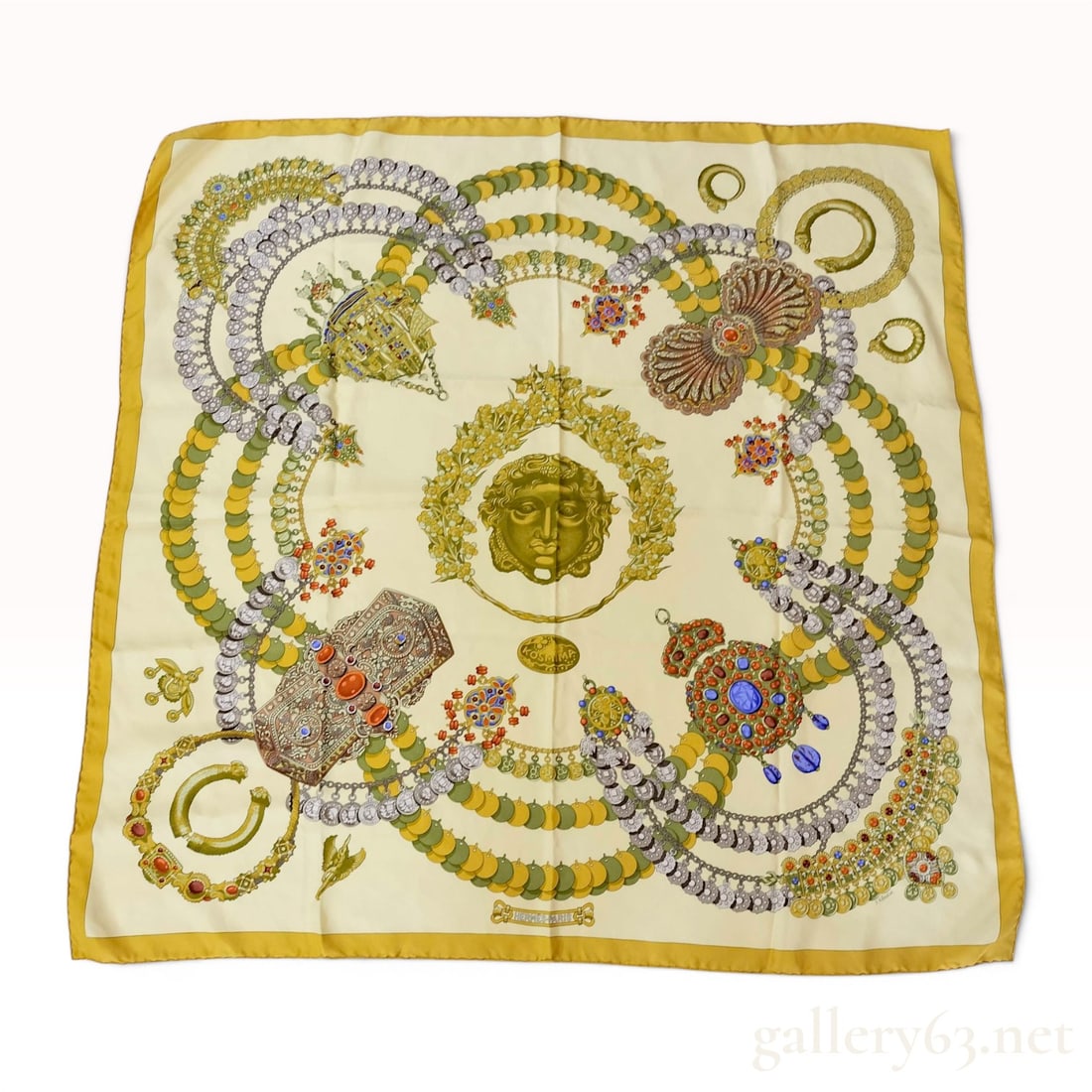 Hermes Kosmima Silk Scarf by Julia Abadie: Hermes Kosmima pattern silk scarf designed by artist Julia Abadie, circa 1994. The 100 percent silk twill square features ancient jewelry motifs and coin necklaces surrounding a central Gorgon head me