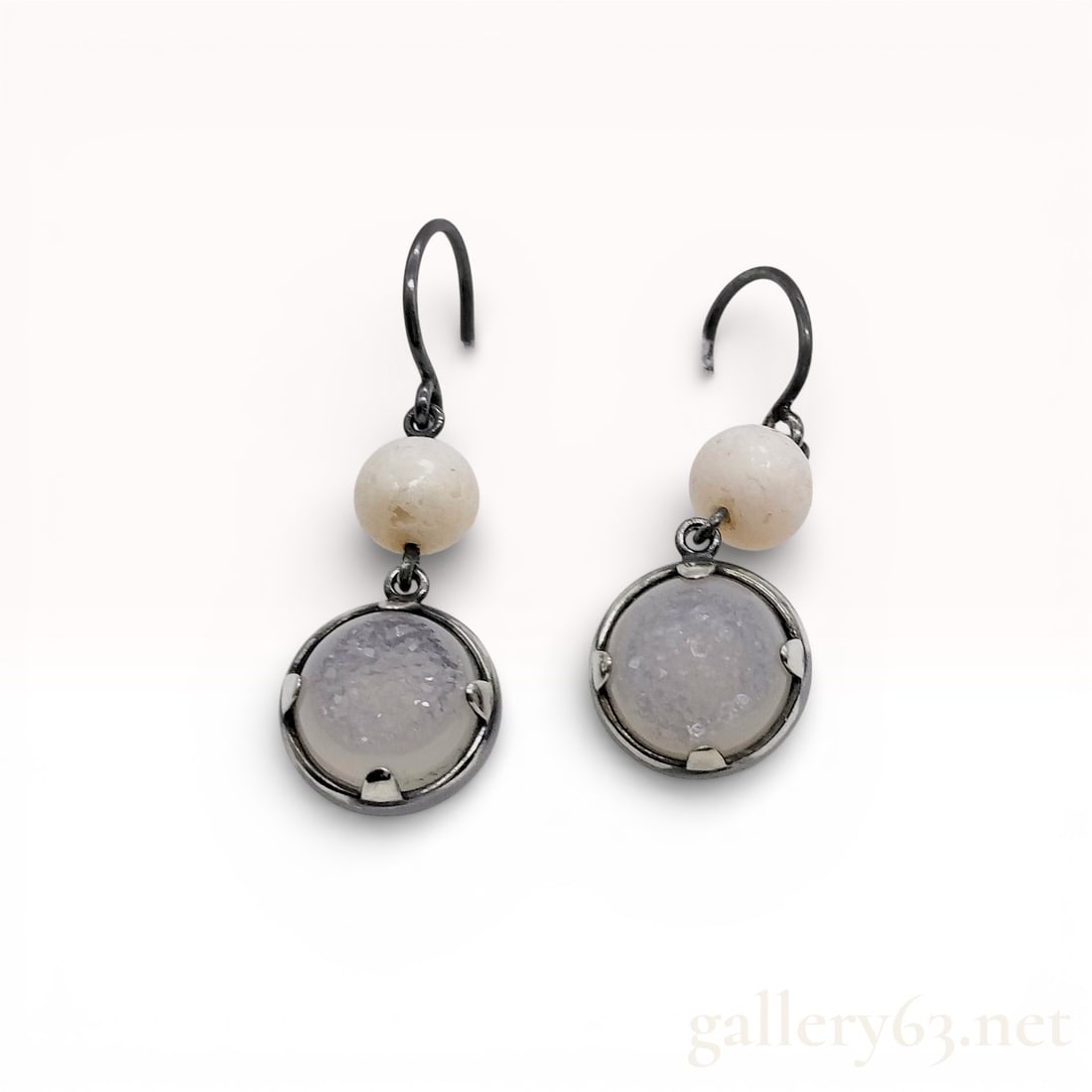 Oxidized Sterling Silver and Druzy Quartz Drop Earrings: A pair of matched drop earrings in darkened sterling silver. Each earring features a two-tiered dangle design, starting with a spherical off-white stone bead suspended from a shepherd's hook ear wire.