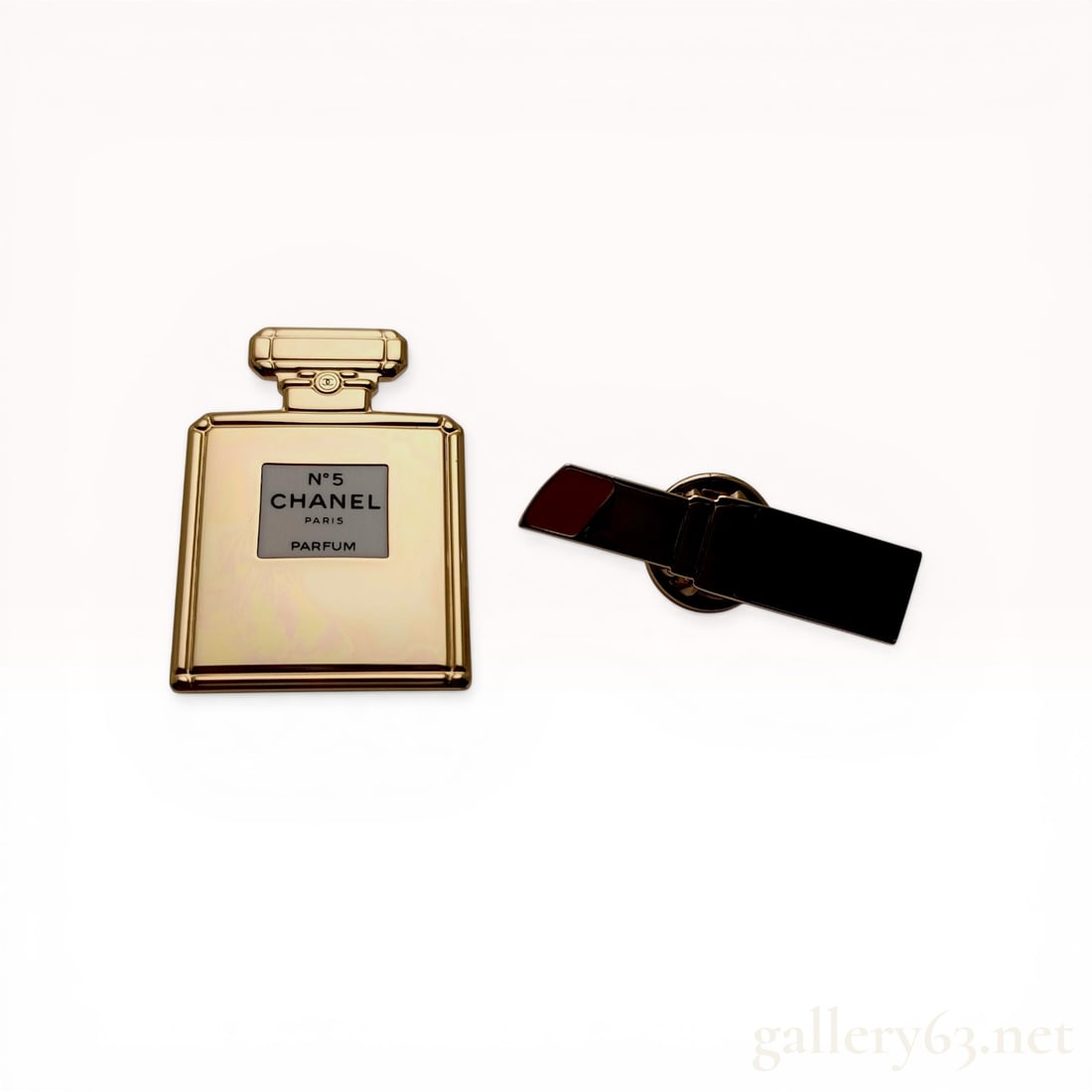 Two Chanel La Collection Gold-Toned Enamel Lapel Pins: A set of two Chanel La Collection promotional lapel pins featuring a No. 5 perfume bottle and a lipstick tube. The perfume bottle pin is constructed of gold-toned metal with a white enamel label and e