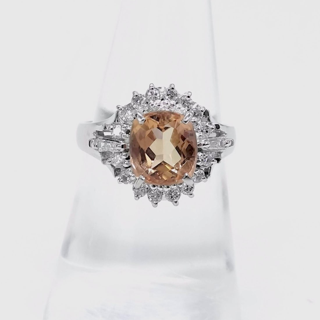 flag - redo, its imperial topaz. Add pics of gem: This sophisticated cocktail ring is crafted in Pt900 platinum and features a prominent oval-cut peach-colored morganite, weighing approximately 2.35 carats. The center stone is secured in an elevated 