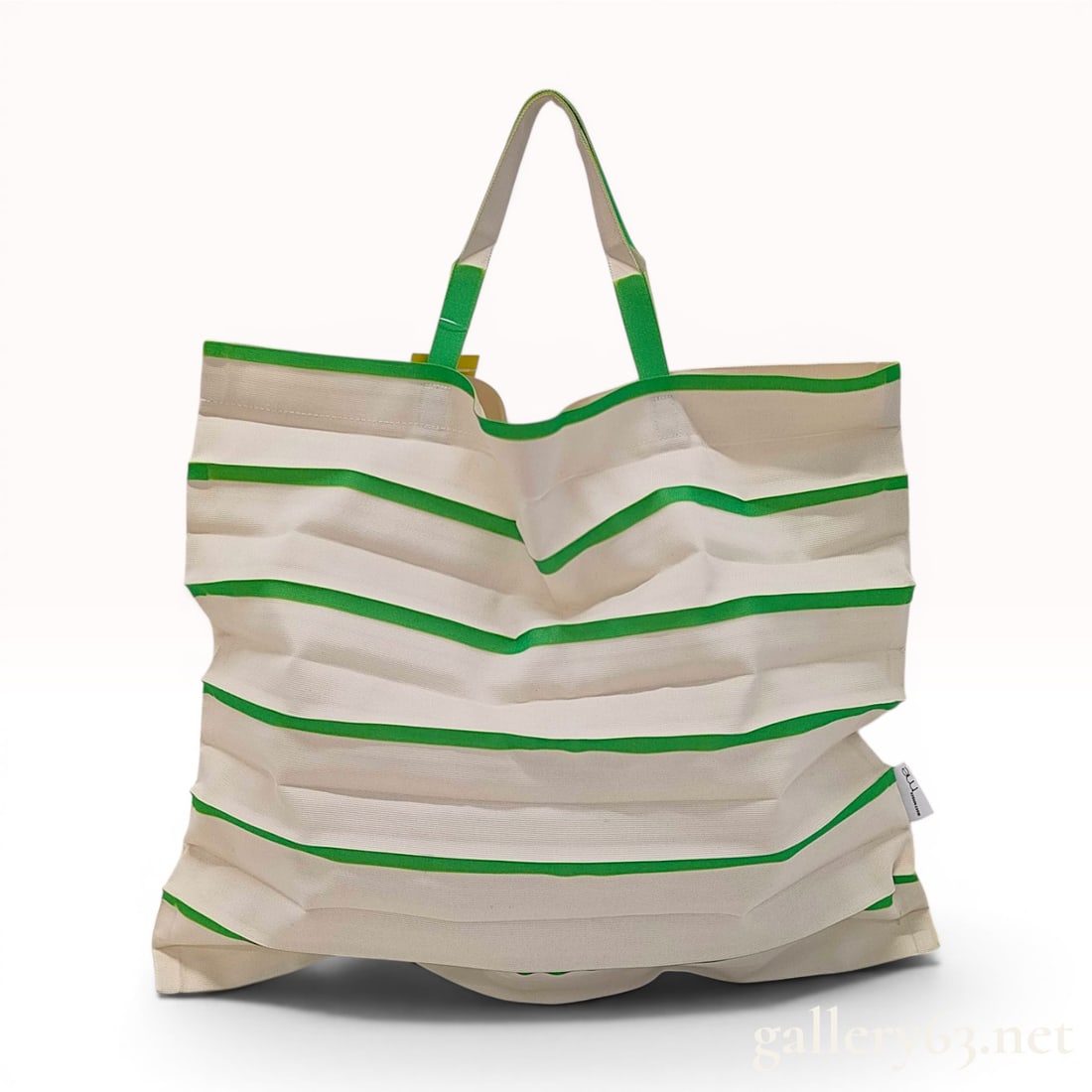 me ISSEY MIYAKE Striped Trunk Pleats Bag in Green and Cream: This tote bag is from the me ISSEY MIYAKE line and features the signature Trunk Pleats design. The bag is constructed from a woven polyester fabric with permanent heat-set accordion pleats, allowing t
