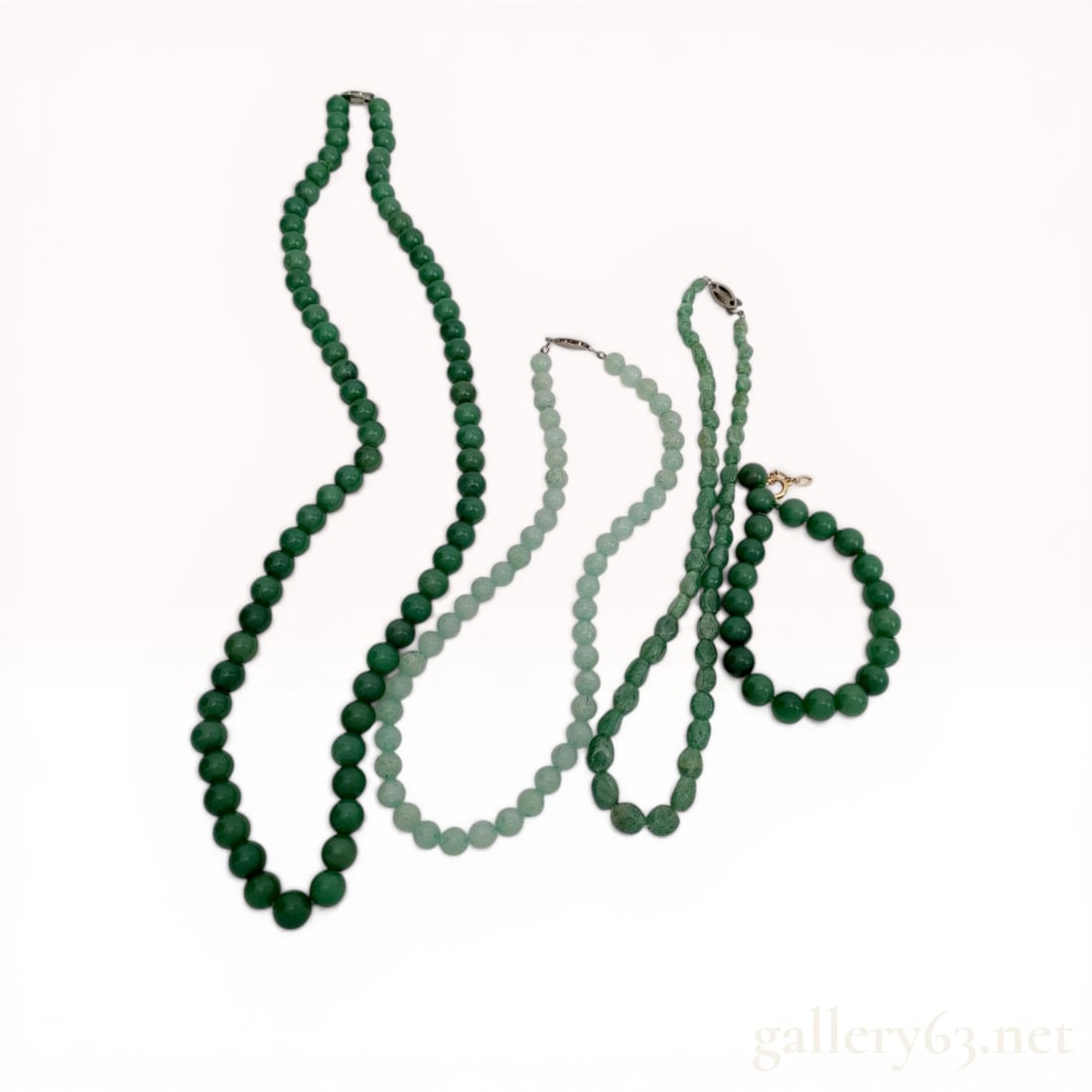 A Collection of Jadeite, Aventurine, and Beaded Stone Necklaces/Bracelets: This group consists of three necklaces and one bracelet featuring various green stone beads, including jadeite, aventurine, and simulated jade. The collection includes a long opera-length knotted neck