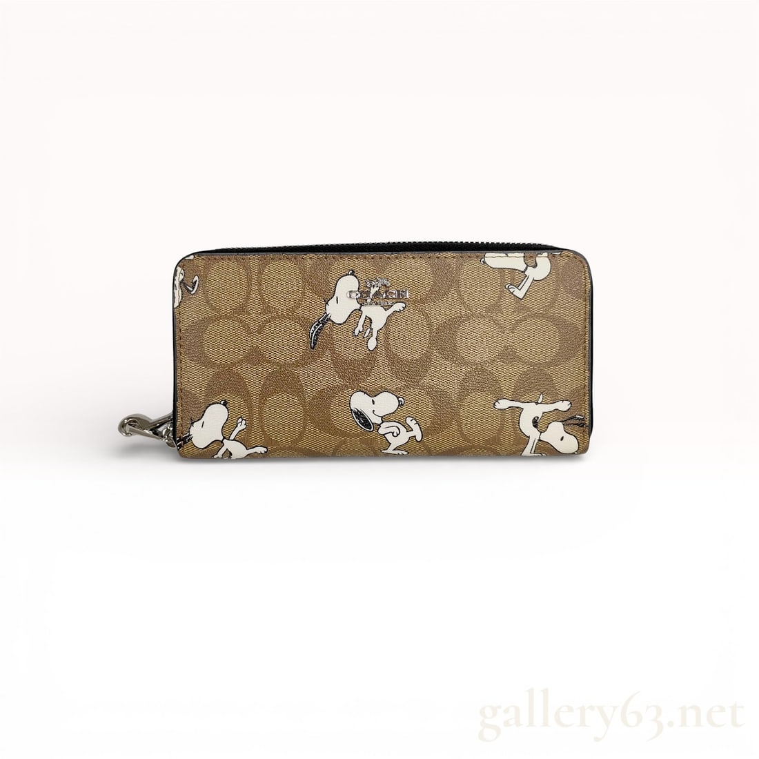 COACH x PEANUTS Long Zip Around Wallet in Signature Canvas with Snoopy: A Coach x Peanuts collaboration long zip-around wallet crafted from signature C coated canvas in tan and brown. The exterior is decorated with multiple white and black illustrations of the character S