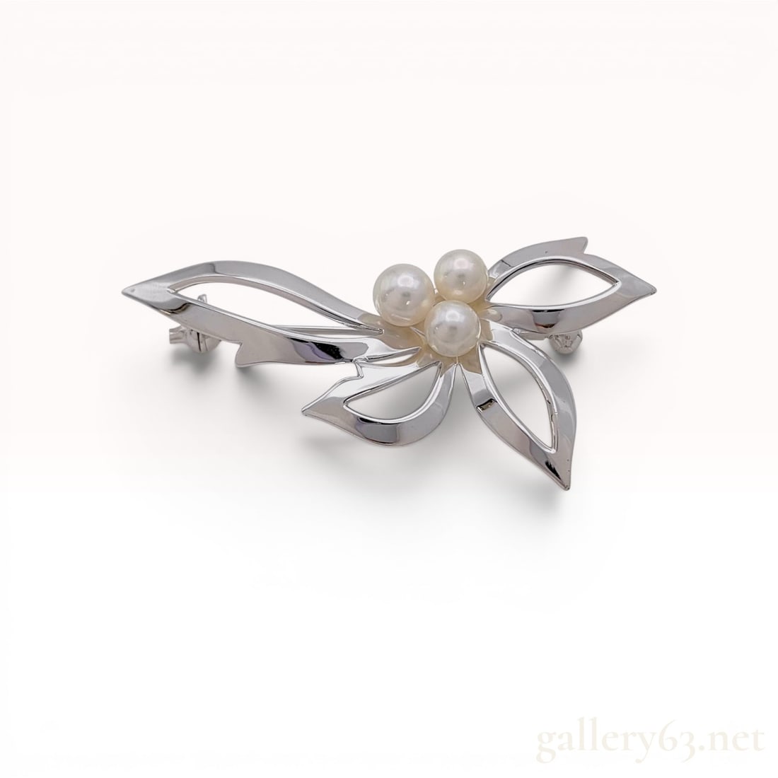 Mikimoto Sterling Silver and Akoya Pearl Floral Spray Brooch: Mikimoto stylized floral spray brooch, mid-20th century. Crafted in sterling silver, the openwork design features asymmetric ribbon-like foliate elements set with three round white Akoya cultured pear