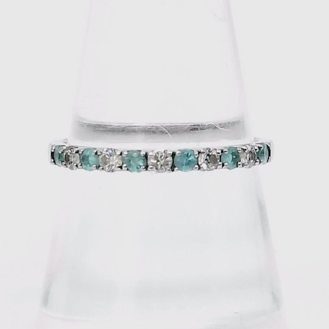Platinum, Paraiba Tourmaline, and Diamond Half-Eternity Band: Platinum half-eternity band featuring five round brilliant diamonds and six round-faceted paraiba tourmaline. The gemstones are mounted in a shared prong setting on a slim, polished shank. The interio
