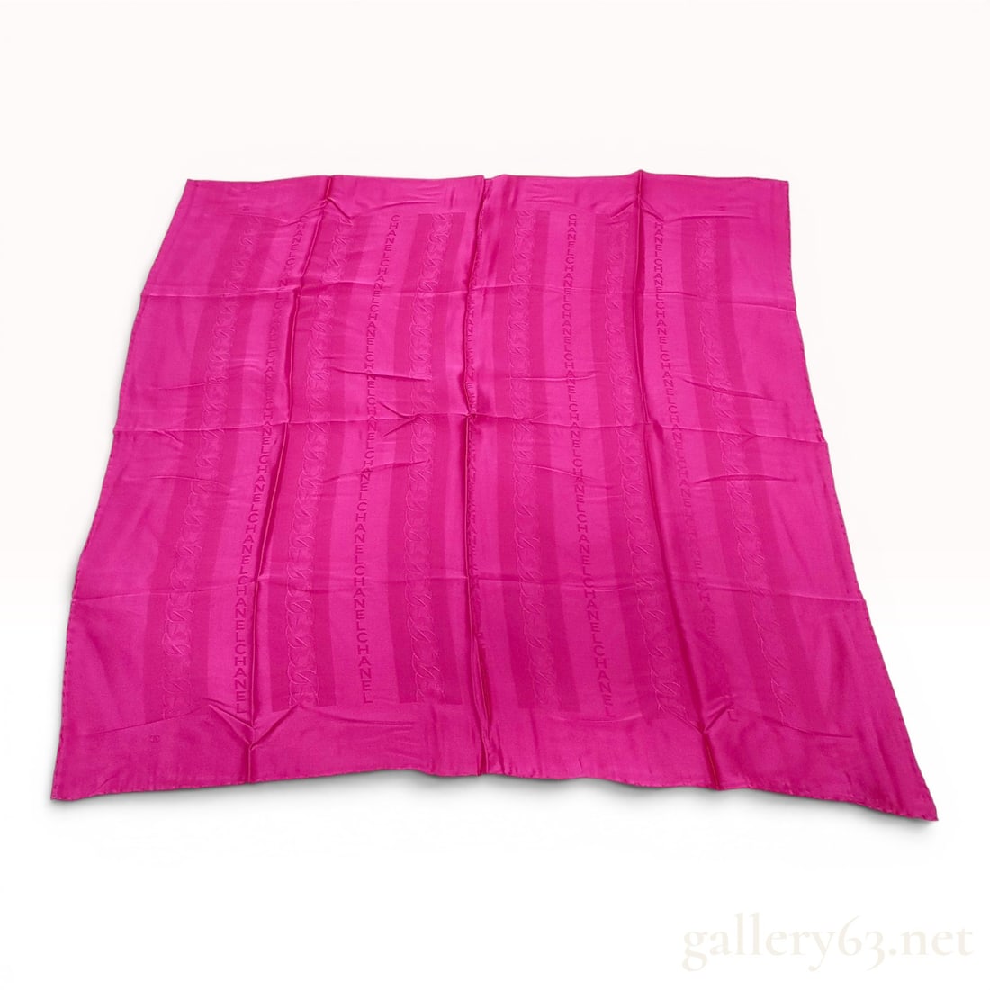 Chanel Fuchsia Silk Jacquard Square Scarf: This square scarf from Chanel is crafted from 100 percent silk in a vibrant fuchsia pink. The fabric features a tonal jacquard-woven pattern of vertical bands. Alternating bands contain repeating vert