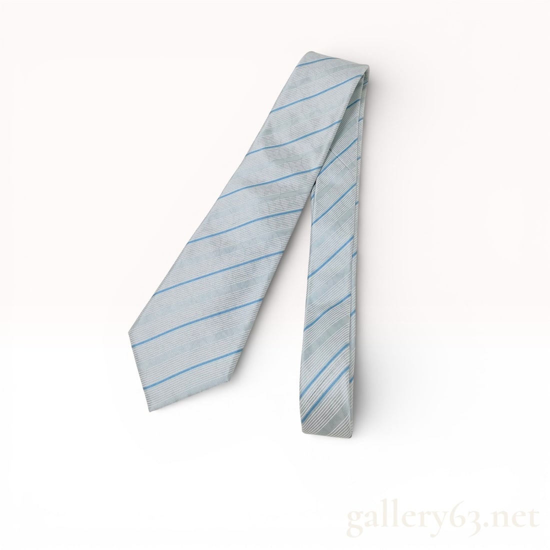 Louis Vuitton Blue and Silver Diagonal Striped Silk Men's Tie: Louis Vuitton silk necktie featuring a diagonal striped pattern in a palette of light blue and silver with white accents. The reverse side includes a dark brown brand label with gold-tone LOUIS VUITTO