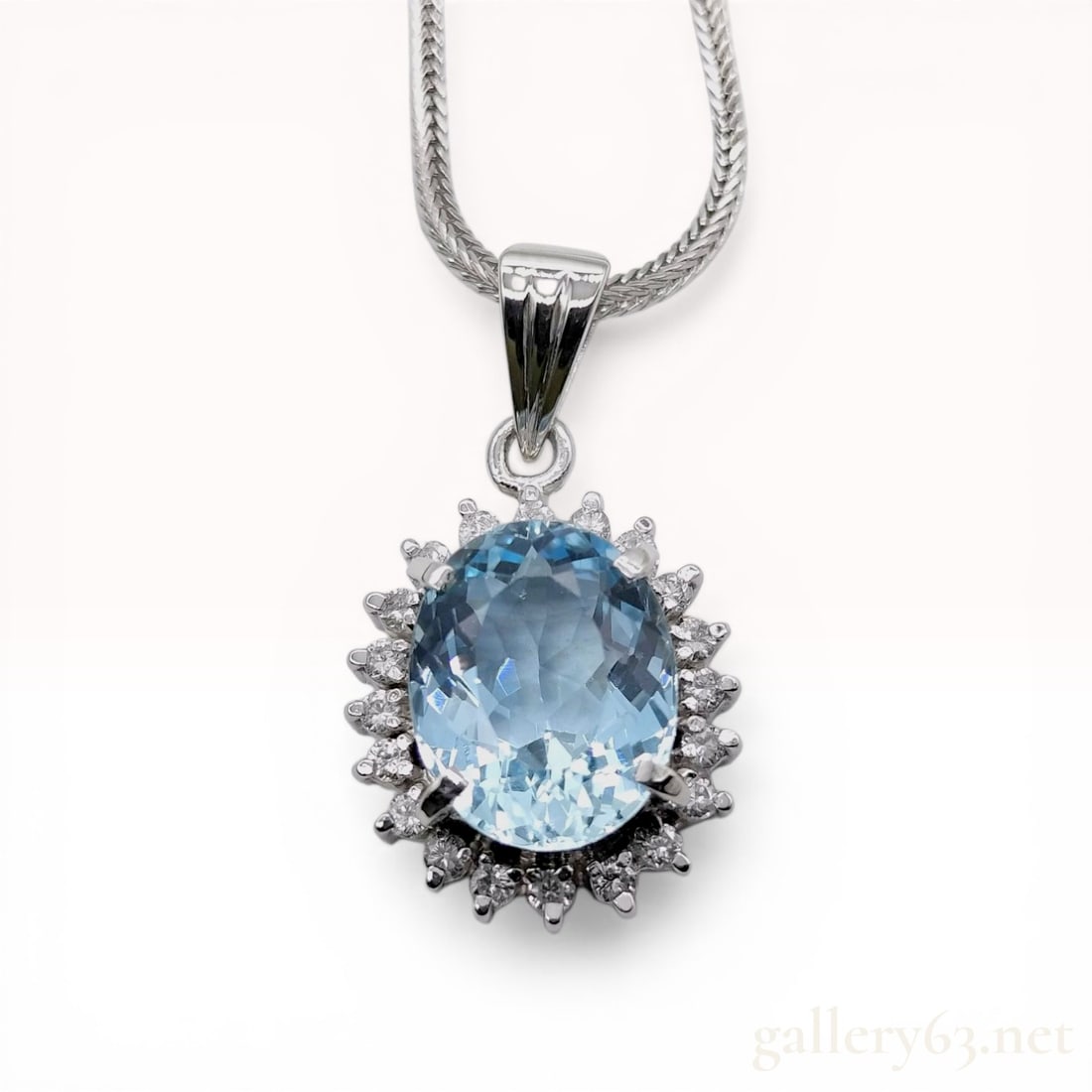 Platinum Aquamarine and Diamond Halo Pendant Necklace: Newly finished necklace. Platinum pendant necklace featuring a central oval-cut natural aquamarine weighing approximately 2.86 carat. The center stone is surrounded by a halo of seventeen round brilli