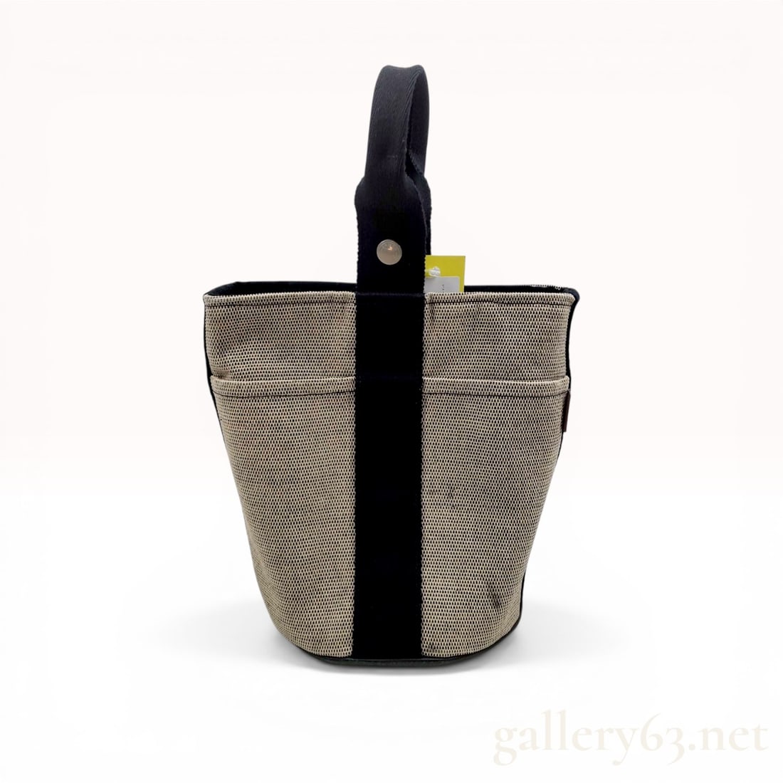 Hermes Saxo PM Bucket Bag: Herm s Saxo PM bucket bag. Crafted from tan and black micro-check woven canvas with black canvas webbing and a single top handle. The exterior features four slip pockets and a branded snap button clos