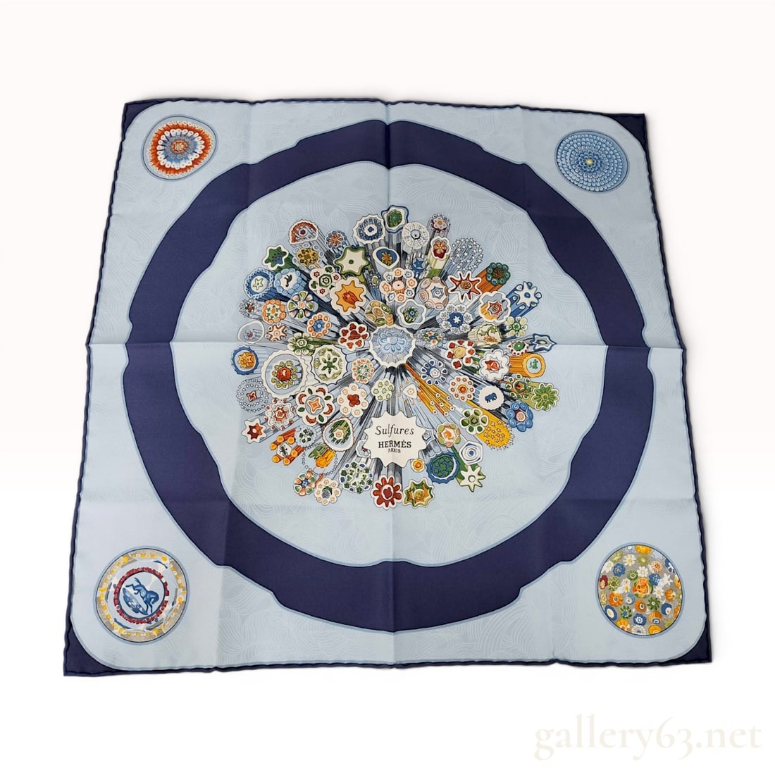 Hermes Sulfures Silk Gavroche Scarf: This Hermes Sulfures silk gavroche scarf, also known as a pocket square, features a design by artist Cathy Latham. The central motif depicts a vibrant cluster of multi-colored millefiori glass canes r