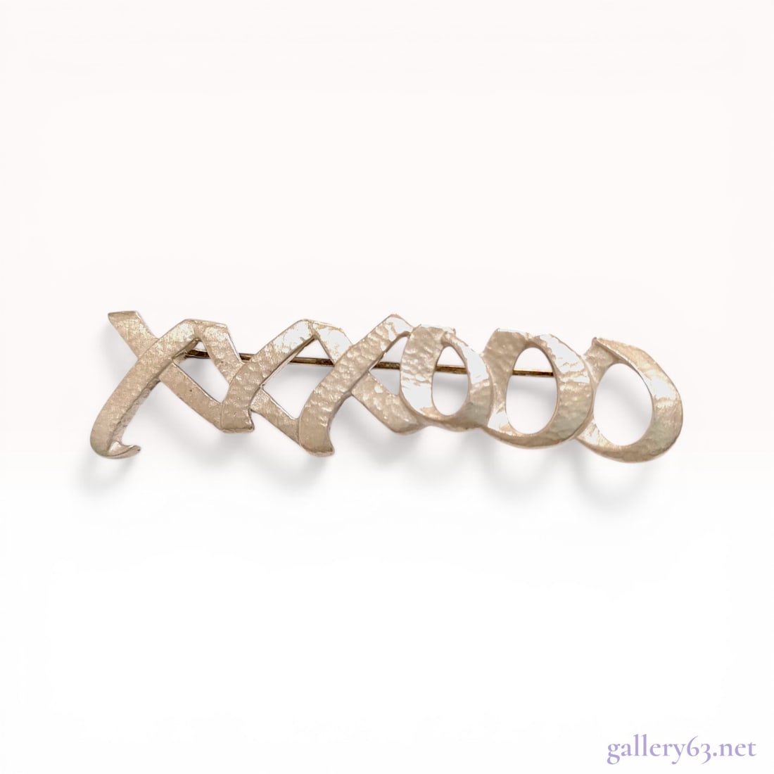 Tiffany & Co. Paloma Picasso Sterling Silver Hugs and Kisses Brooch+J187: Tiffany Co. sterling silver bar brooch designed by Paloma Picasso, circa 1983. The piece features an interlocking XXXOOO motif with a textured hammered finish and a hinged pin back with a revolving sa