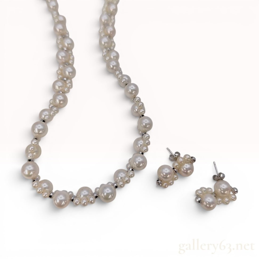 Kawasumi Cultured Pearl and 14K White Gold Necklace and Earring Set: A jewelry set by Kawasumi featuring a necklace and matching stud earrings composed of cream-colored cultured pearls and faceted white metal spacer beads. The necklace is designed with repeating cluste