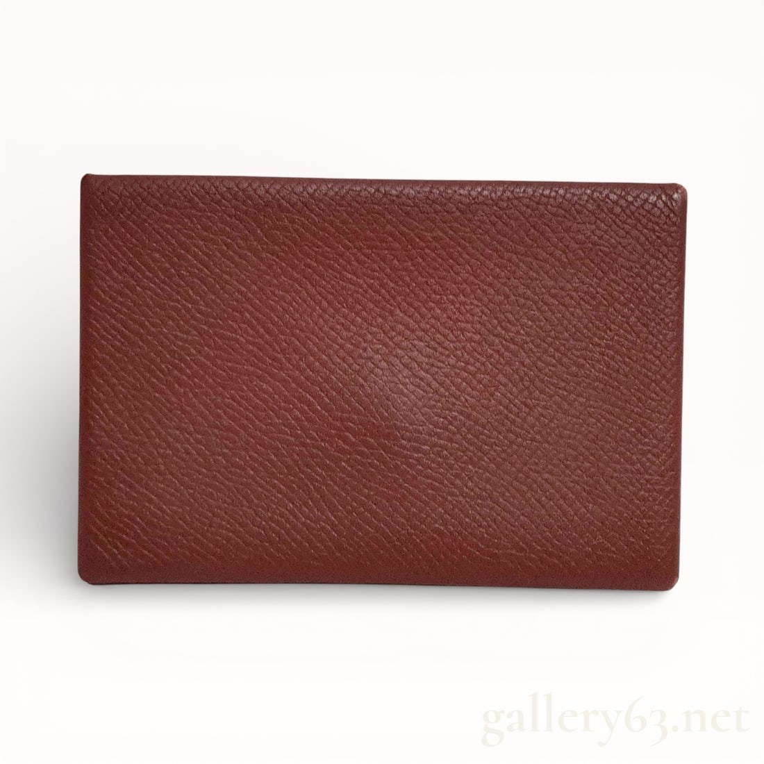 Hermes Calvi Coin Case in Brown Grained Leather with A-Engraving: Authentic Hermes Calvi coin case crafted in brown grained leather, featuring a slim rectangular profile with envelope-style snap closure. Clean exterior with fine grain texture and precise edge finish