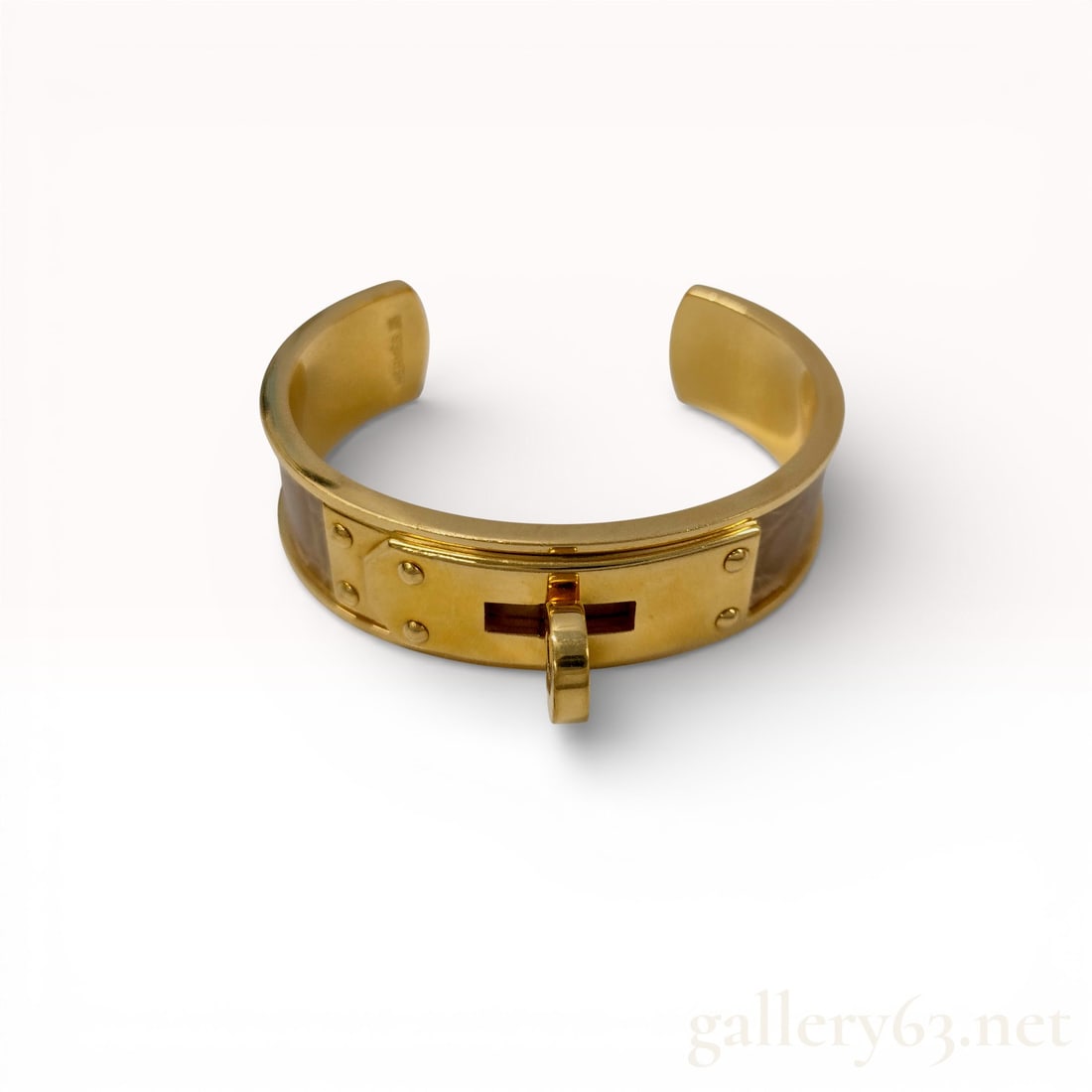 Hermes Kelly Dog Exotic Skin Cuff Bracelet: Hermes Kelly Dog cuff bracelet featuring gold-toned metal and a light taupe exotic skin inlay. The design includes the signature turn-lock hardware and studded plates on an open-back cuff frame. The i