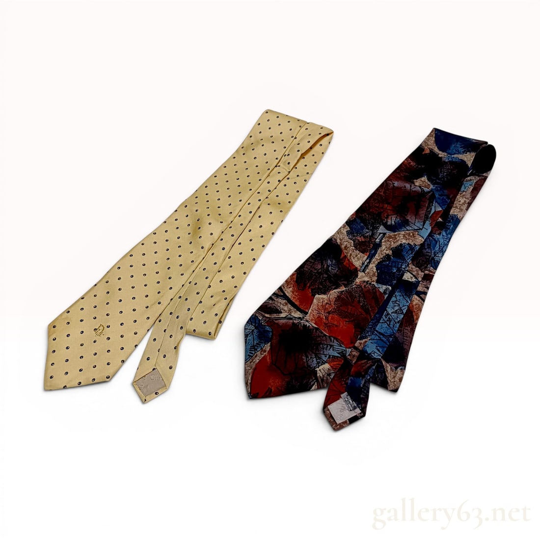 Two Christian Dior Silk Neckties: This lot features two silk neckties from Christian Dior. The first is a yellow silk necktie with a repeating pattern of small blue polka dots and an embroidered tonal logo on the front blade. It inclu
