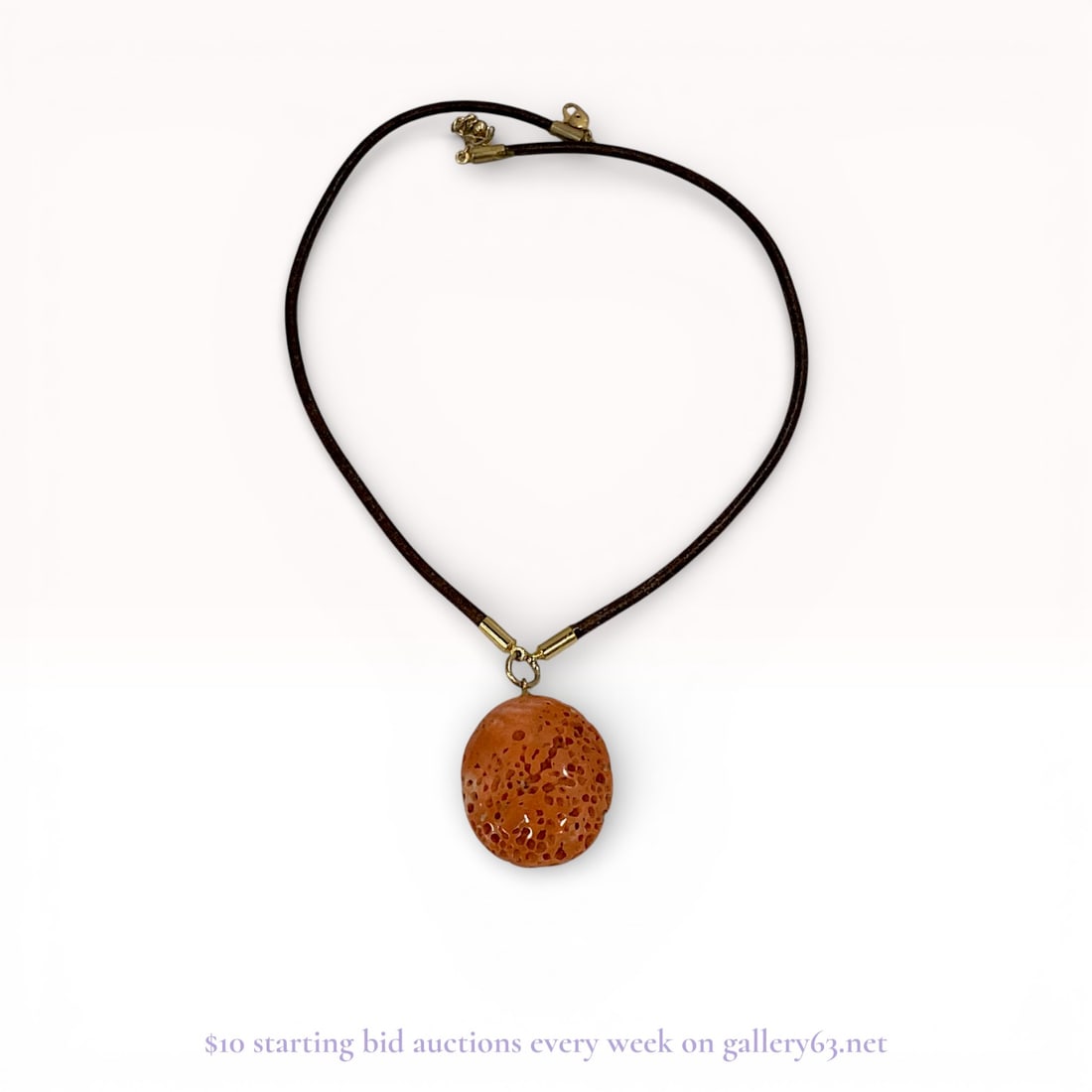 Sponge Coral Pendant on Leather Cord Necklace: Contemporary pendant necklace featuring an oval sponge coral cabochon in a vibrant orange-salmon hue. The coral displays a natural porous texture and is suspended from a dark brown leather cord via go