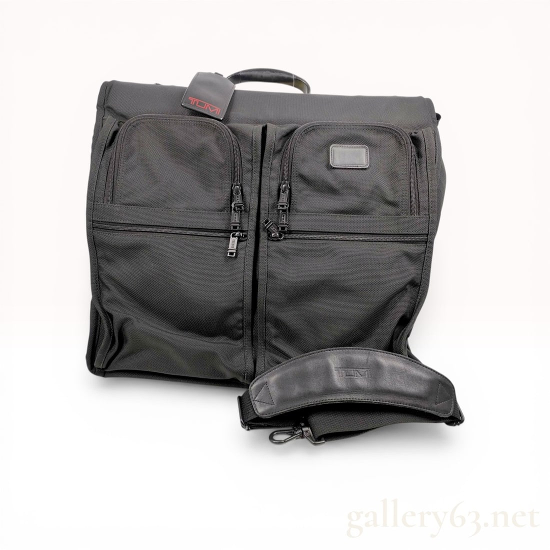 Tumi Alpha Black Ballistic Nylon Tri-Fold Garment Bag: Tumi Alpha tri-fold garment bag crafted from durable black ballistic nylon with leather trim and black-finished metal hardware. The exterior features two large U-zip pockets, two horizontal zip pocket