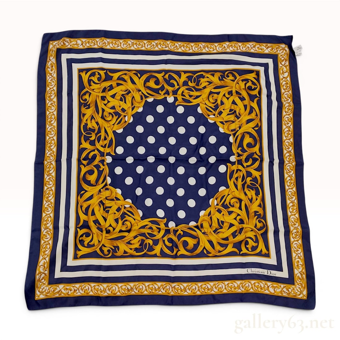 Christian Dior Polka Dot and Acanthus Leaf Silk Scarf: This square silk scarf by Christian Dior features a navy blue central field decorated with white polka dots. This central field is framed by an ornate golden-yellow acanthus leaf scrollwork border. Th