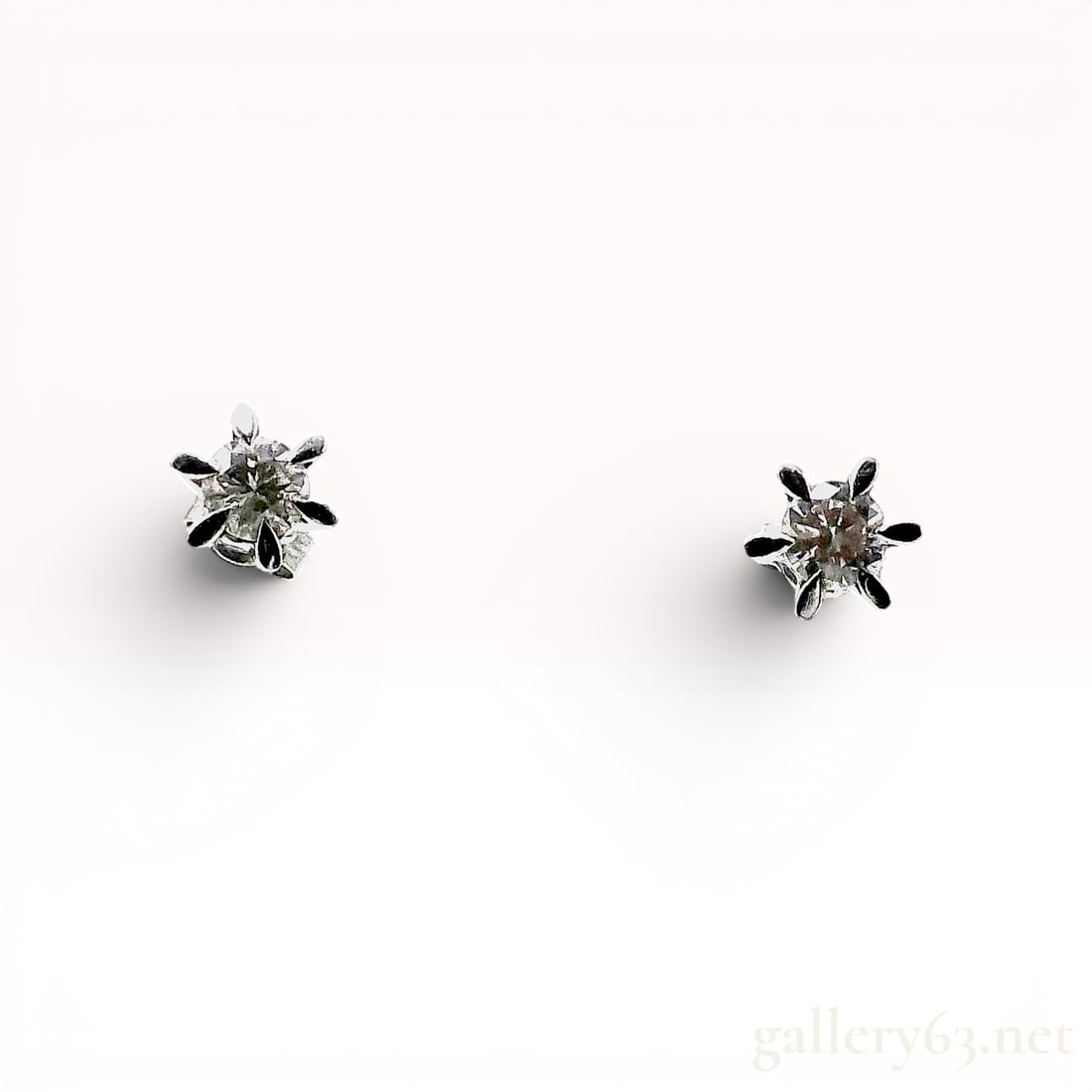 A Pair of Platinum and Diamond Solitaire Stud Earrings: Matched pair of platinum and diamond solitaire stud earrings in classic six-prong basket settings. Each earring features a round brilliant cut diamond secured with a post and butterfly backing. The ea