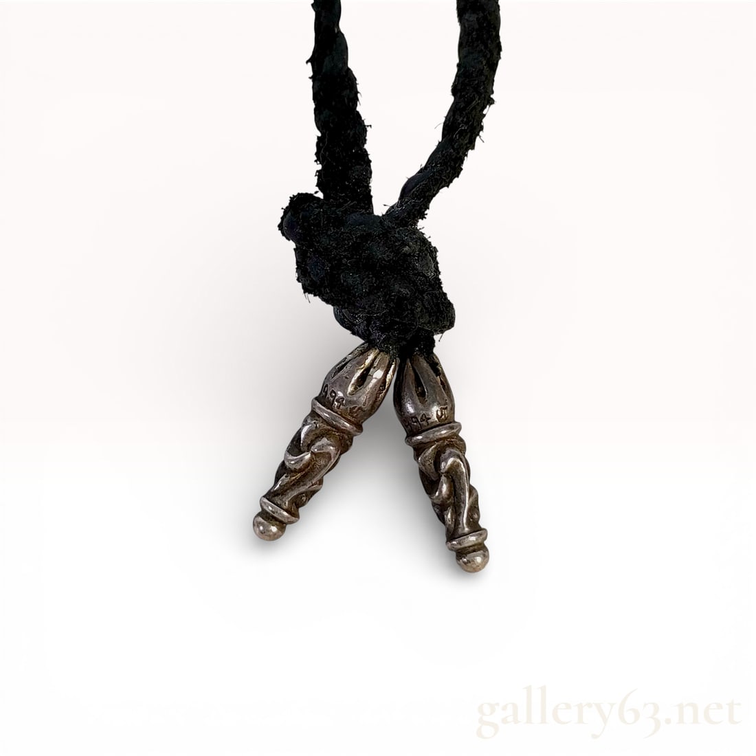 c. 1994 Chrome Hearts Sterling Silver Braided Leather Necklace: This sterling silver and black braided leather necklace by Chrome Hearts features a continuous loop design. The braided leather cord is knotted at the base to secure two ornate sterling silver tips wi