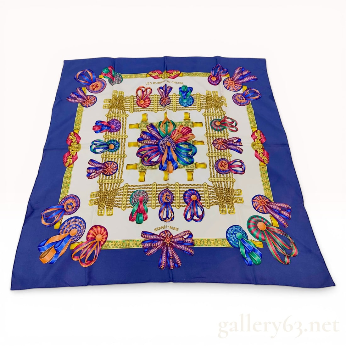 Hermes Les Rubans du Cheval Silk Scarf by Joachim Metz: Hermes silk twill scarf in the Les Rubans du Cheval pattern designed by artist Joachim Metz, originally issued in 1993. The design features a central array of multi-colored horse rosettes and ribbons 