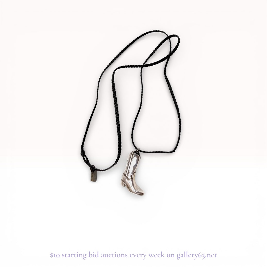 Sterling Silver Cowboy Boot Pendant Braided Cord Necklace: Western style necklace featuring a three-dimensional silver-tone metal cowboy boot pendant with decorative stitch-line details. The pendant is mounted on a black braided cord designed with a knotted s