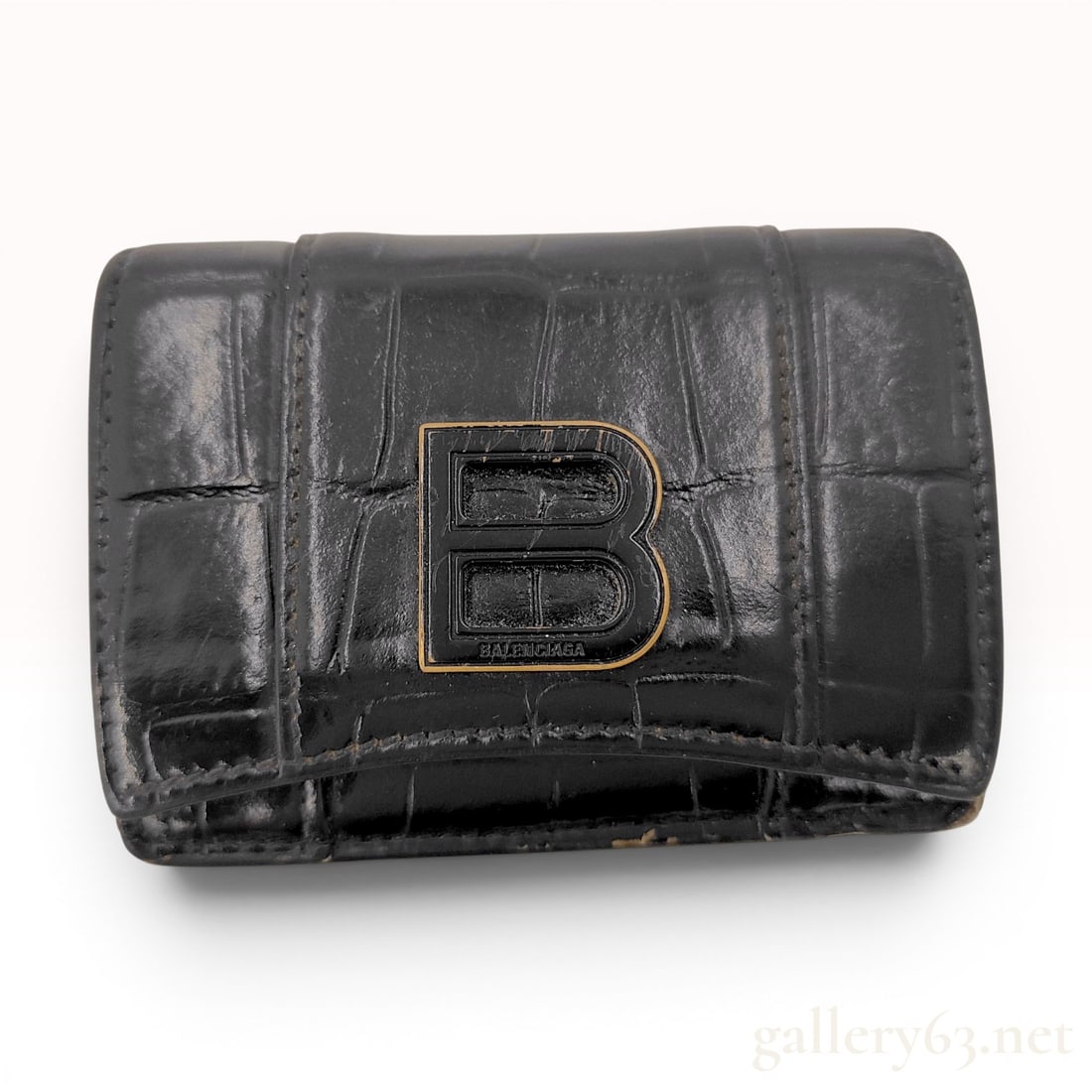 Balenciaga Hourglass Mini Trifold Wallet in Black Croc-Embossed Leather: A Balenciaga compact trifold wallet from the Hourglass collection. The exterior is constructed from black crocodile-embossed leather, featuring a curvilinear base. The front flap is adorned with a bla