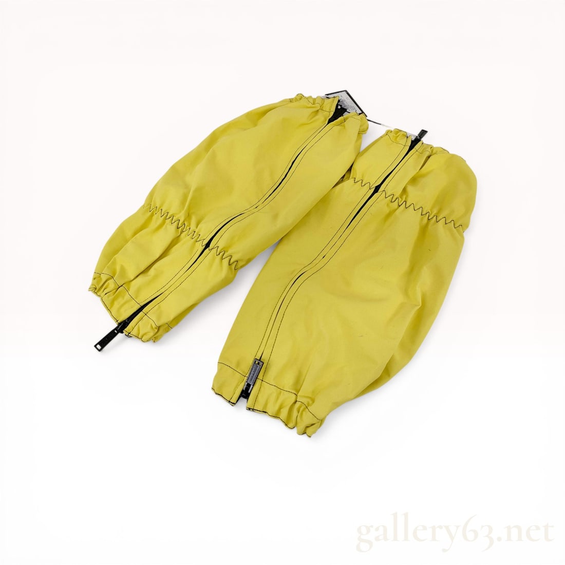 A Pair of Dsquared2 Ski Acid Yellow Technical Zippered Gaiters: Dsquared2 Ski collection technical over-boot gaiters in acid yellow. The synthetic shell features black contrast zigzag stitching, elasticated hems, and a breathable black mesh lining. Each gaiter inc