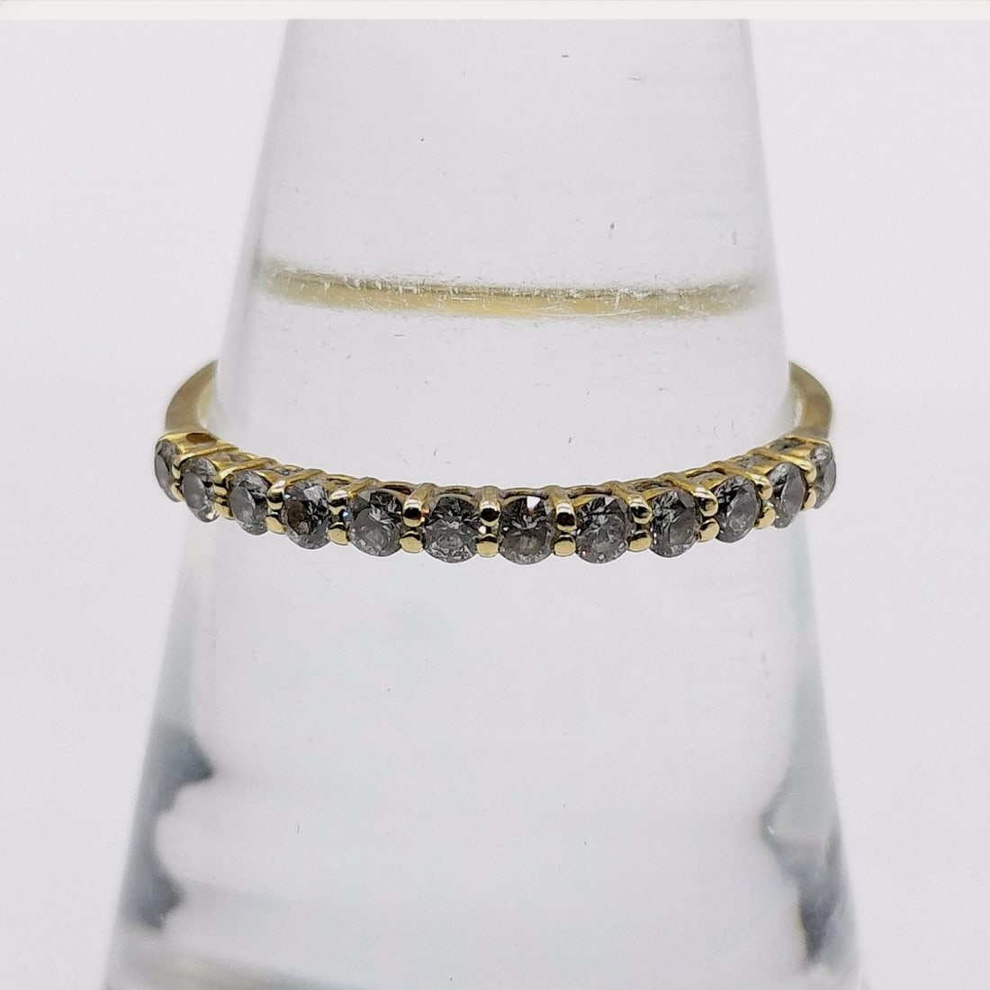 18K Yellow Gold and Salt and Pepper Diamond Half-Eternity Band: An 18K yellow gold half-eternity band featuring fifteen round-cut salt and pepper diamonds. The diamonds exhibit a dark grey tone with prominent internal inclusions and are secured in a bead-style pro