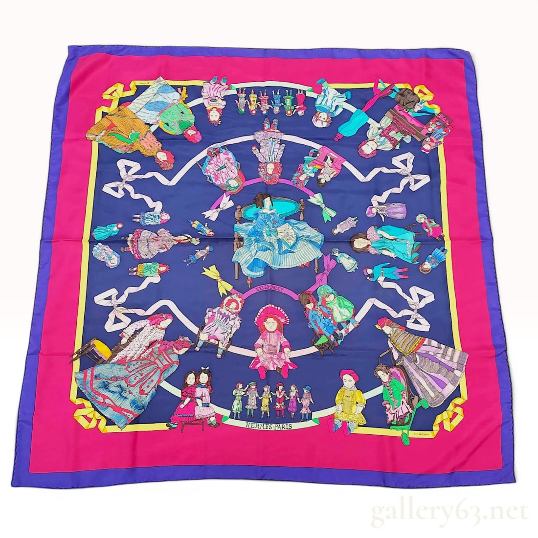 Hermes Hello Dolly Silk Scarf by Loic Dubigeon: Hermes 100% silk twill scarf featuring the Hello Dolly pattern, designed by artist Loic Dubigeon. The design comprises a navy blue center field with a central illustration of a woman in a blue tiered 