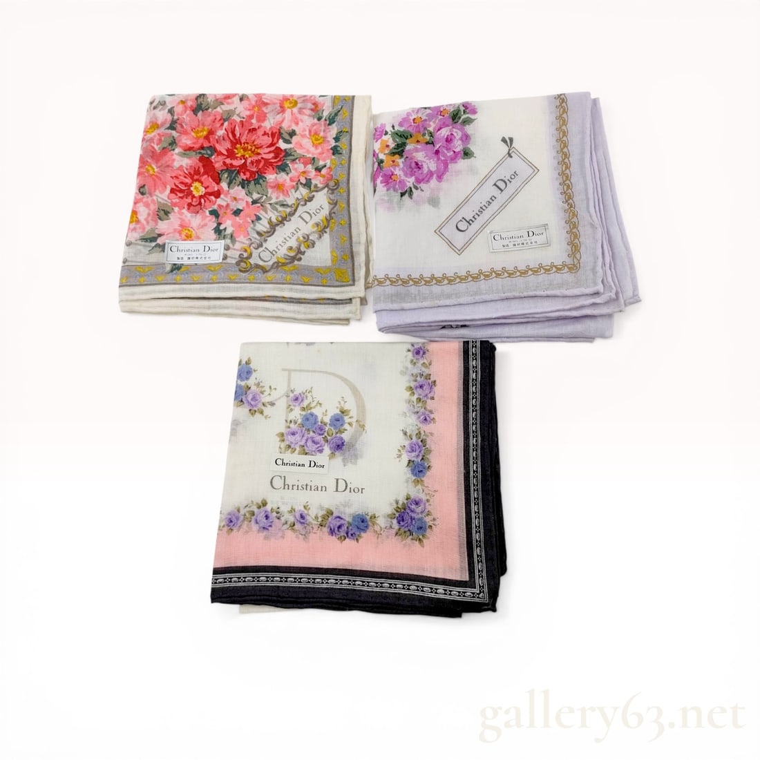 Three Christian Dior Floral Cotton Scarves: Christian Dior, trio of floral cotton scarves. late 20th century. Each piece features a unique floral motif including peonies and roses on a white field with decorative borders and printed signatures.