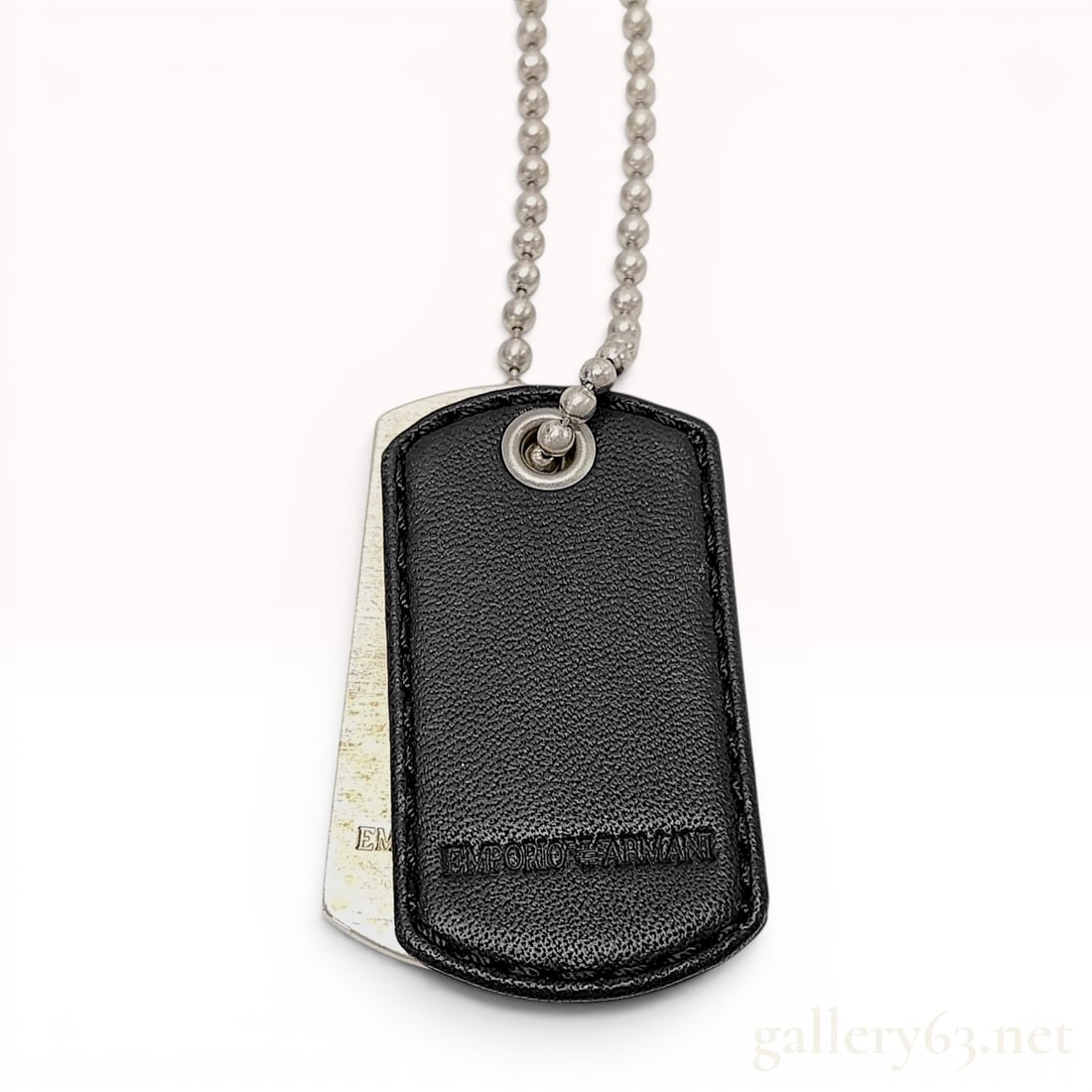 Emporio Armani Sterling Silver and Black Leather Double Dog Tag Necklace: This pendant necklace by Emporio Armani features a double dog tag design. The piece consists of one sterling silver tag and one black pebbled leather tag, both suspended from a sterling silver ball ch