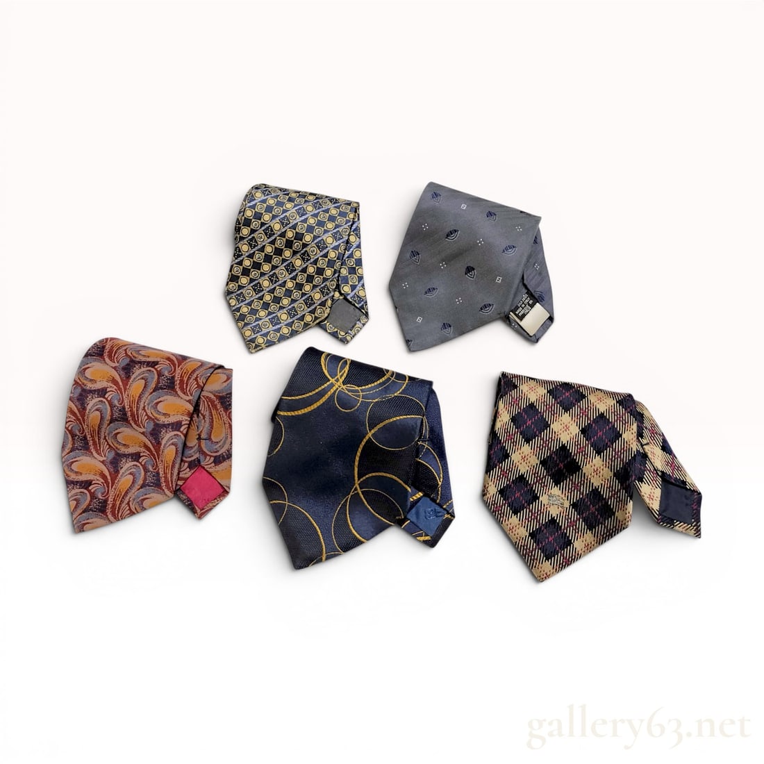 Five Designer Silk Neckties including Fendi, Yves Saint Laurent, Balenciaga, Burberrys, and: This lot consists of five designer silk neckties from various luxury labels. The collection includes a Fendi tie featuring a grey diagonal ribbed ground with a repeating motif of small FF logos, styli