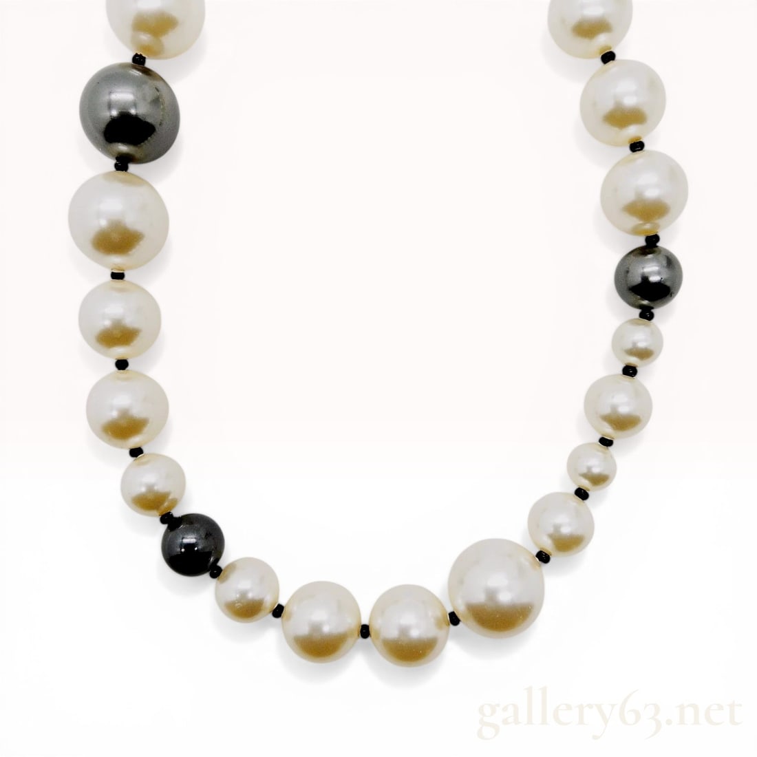 Chanel 2006 Autumn Collection Graduated Faux Pearl Necklace: Chanel graduated faux pearl necklace from the 2006 Autumn collection. The single strand features white and charcoal-grey faux pearls individually knotted on a black cord with gold-toned metal hardware